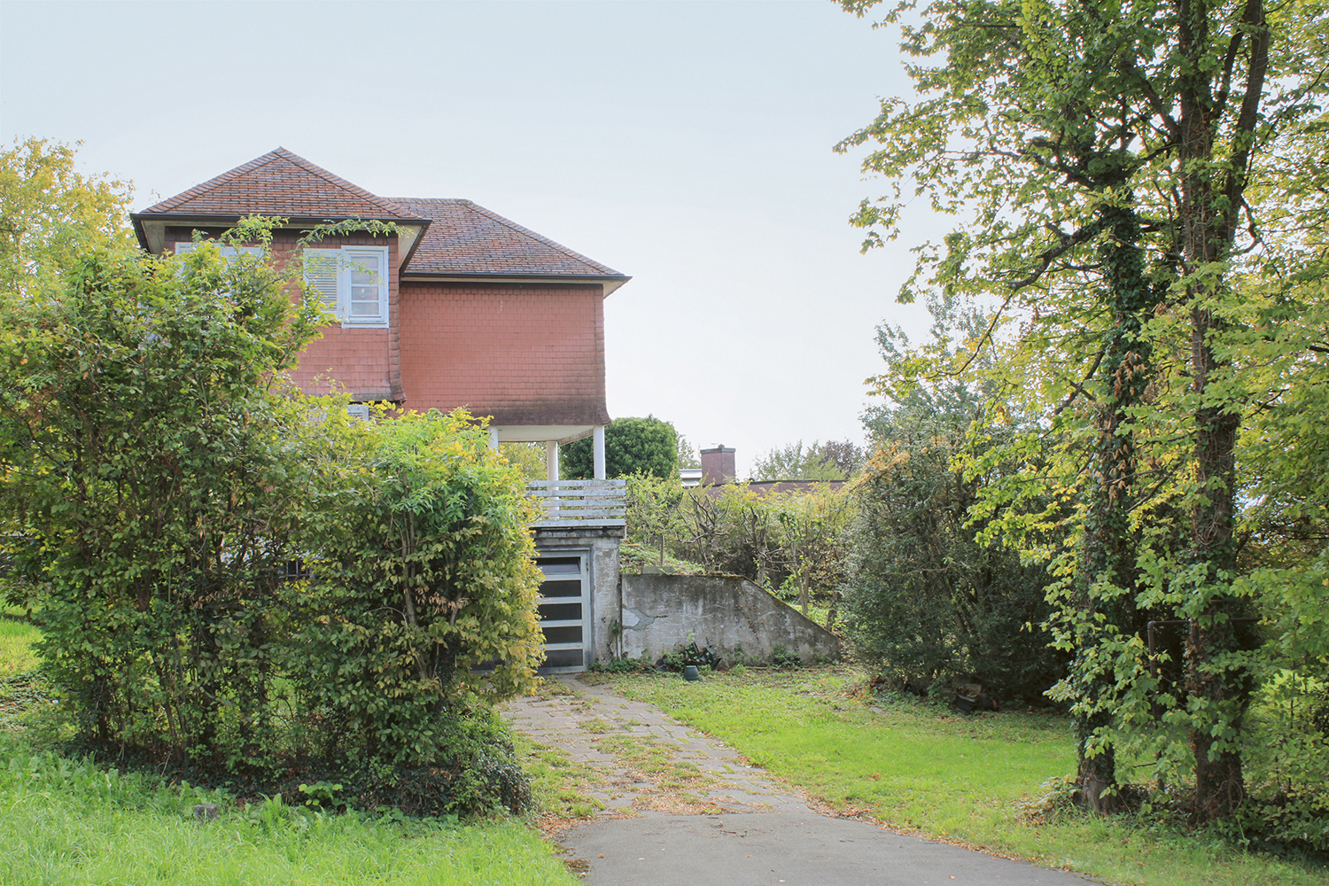 Im Vordergrund steht das Rebhaus von Lux Guyer. Dahinter ist das Dach des Wohnhauses Gelpke-Engelhorn  von Beate Schnitter zu erkennen. Die Nähe und das gesamte Ensemble der fünf Bauten von Guyer und Schnitter sind einmalig in der Schweiz.