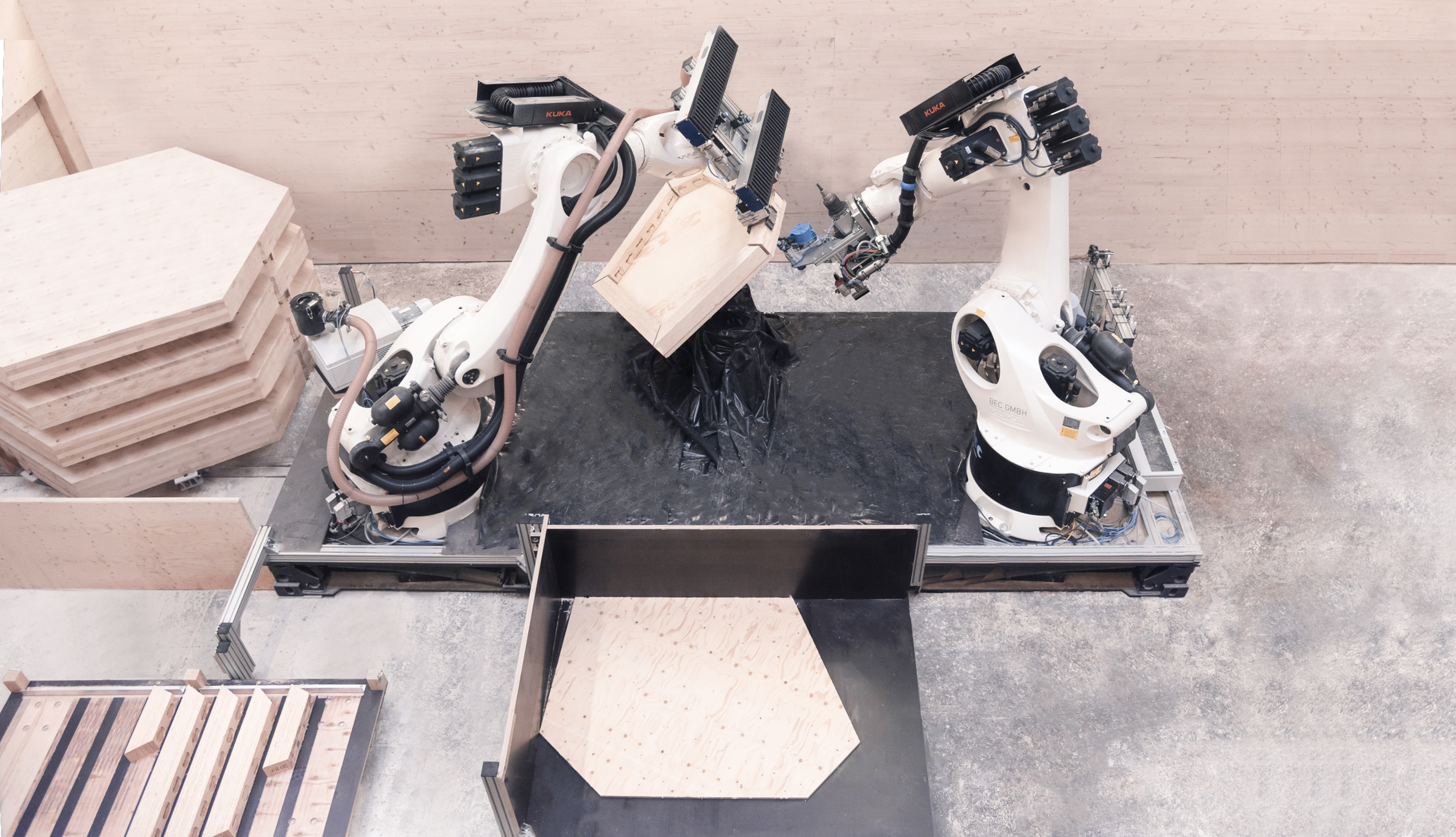 Ansicht der robotischen Vorfertigungsanlage mit Materialzufuhr und Klebepresse.