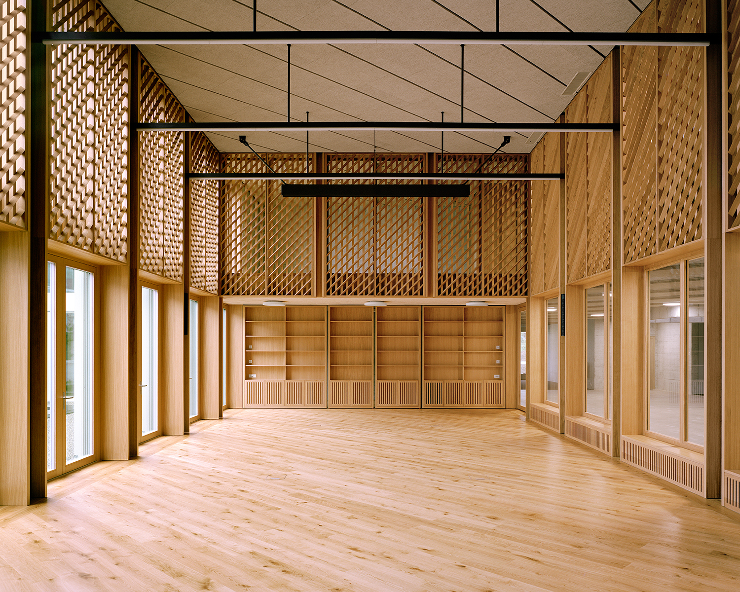 Das in Holz gekleidete Lernatelier fügt sich räumlich zwischen Patio und Foyer und schafft Blickbezüge zwischen Erd- und Obergeschoss.