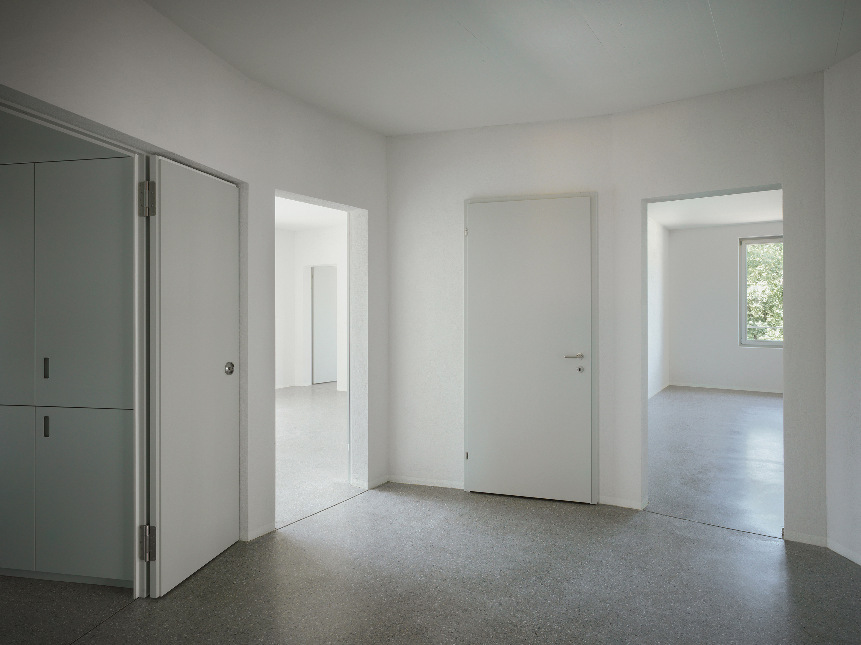 Der durchgängige Bodenbelag aus geschliffenem Hartbeton eint die Räume.