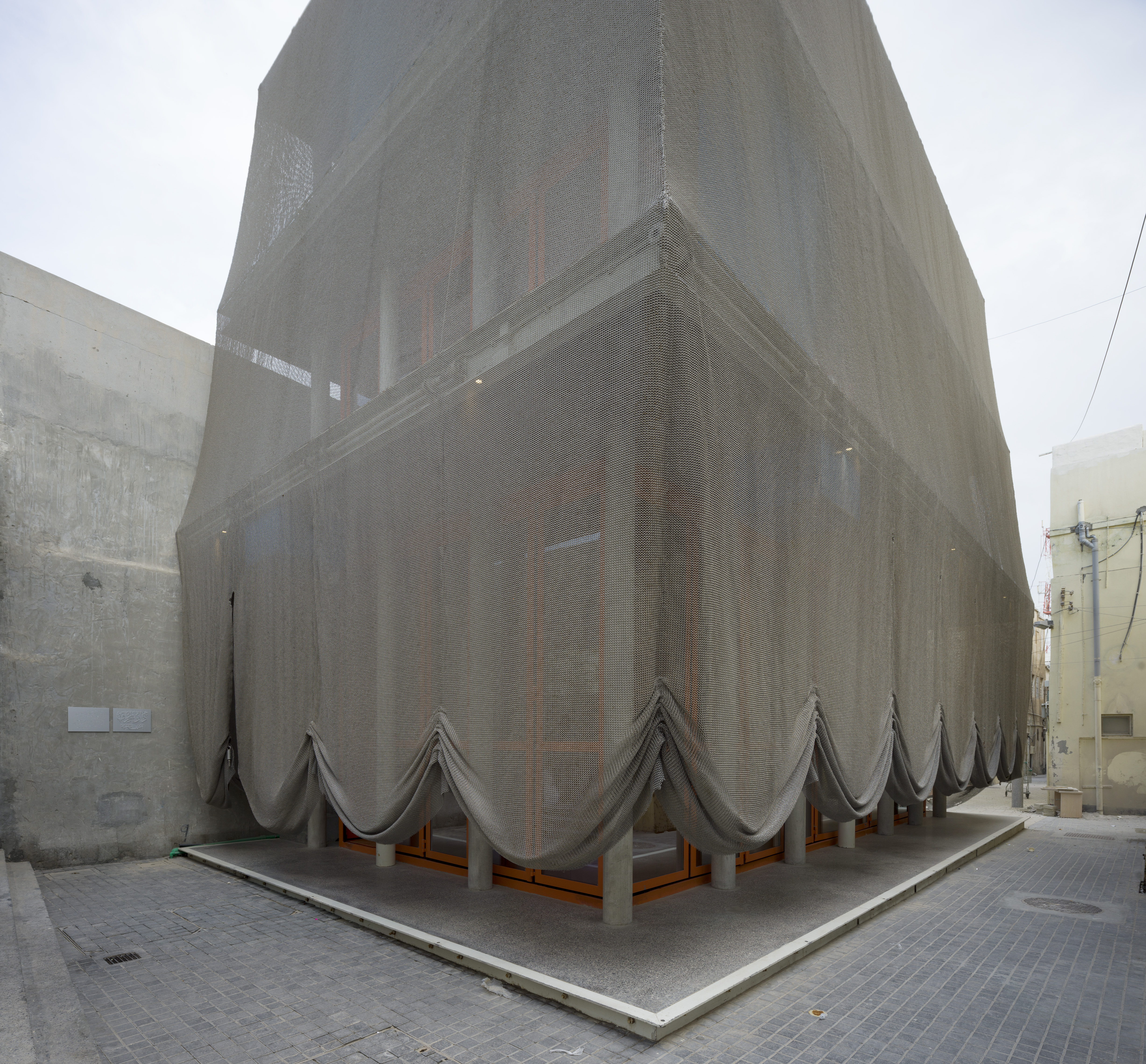 Exterior view of Dar Al Jinaa Center for Traditional Music and its chain mail curtain