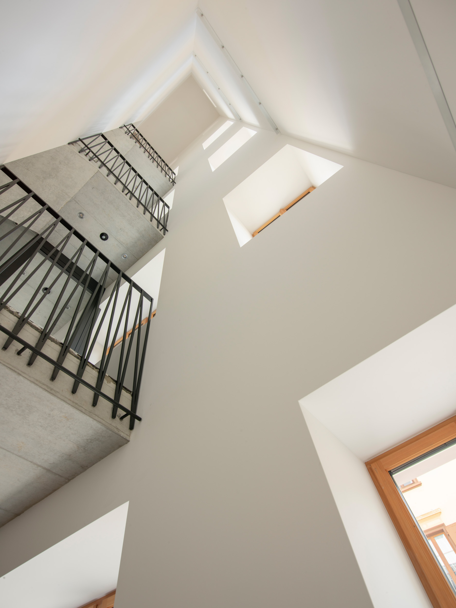 Die Erschliessung mit Treppe gewährt Einblick in eine grosszügige Raumhöhe.
