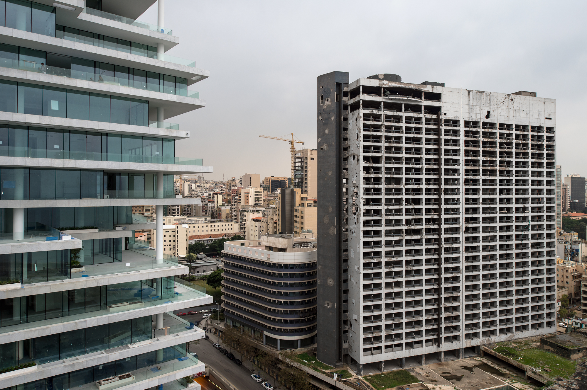 Der Holiday- Inn Tower, eine emblematische Ruine aus dem Bürgerkrieg, angrenzend an die von Herzog &amp; de Meuron entworfene luxuriöse Wohnanlage im Viertel Minet el Hosn.