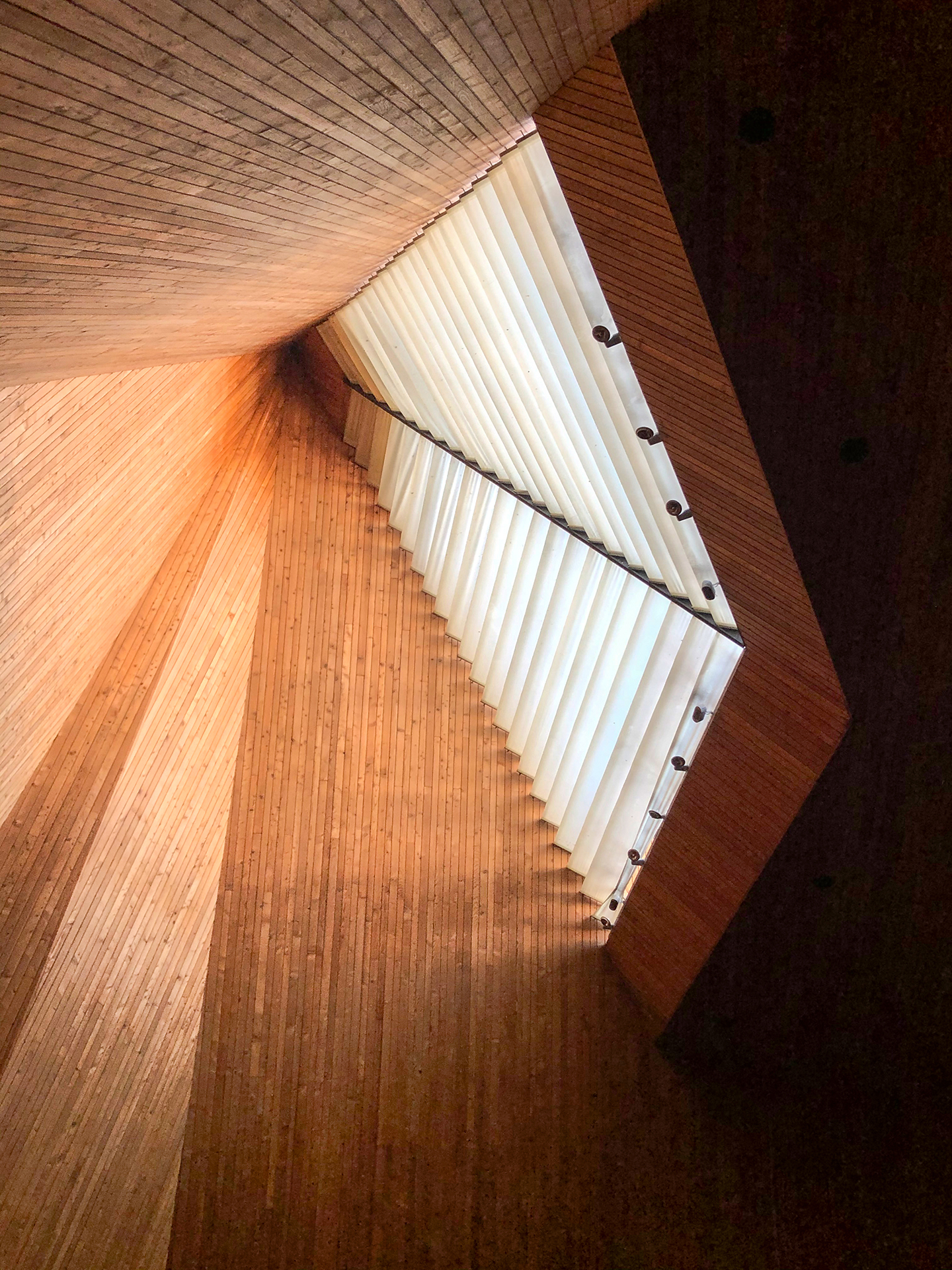 Kirche Maria Krönung, Zürich Witikon: Richtet man den Blick vom Altar zurück Richtung Saal und in die Höhe, lüftet sich das Geheimnis um das gefilterte Tageslicht.