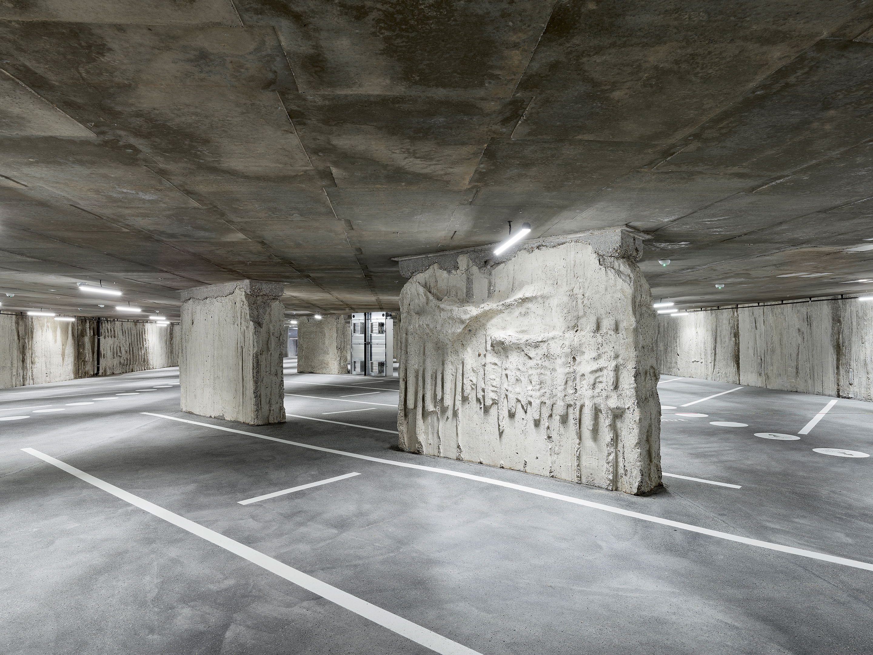 Vorangehende Seite: Die expressiven Betonoberflächen  der Parking-Geschosse ergeben sich aus der Bauweise, die   wiederum den geologischen und organisatorischen Bedingungen  geschuldet war.