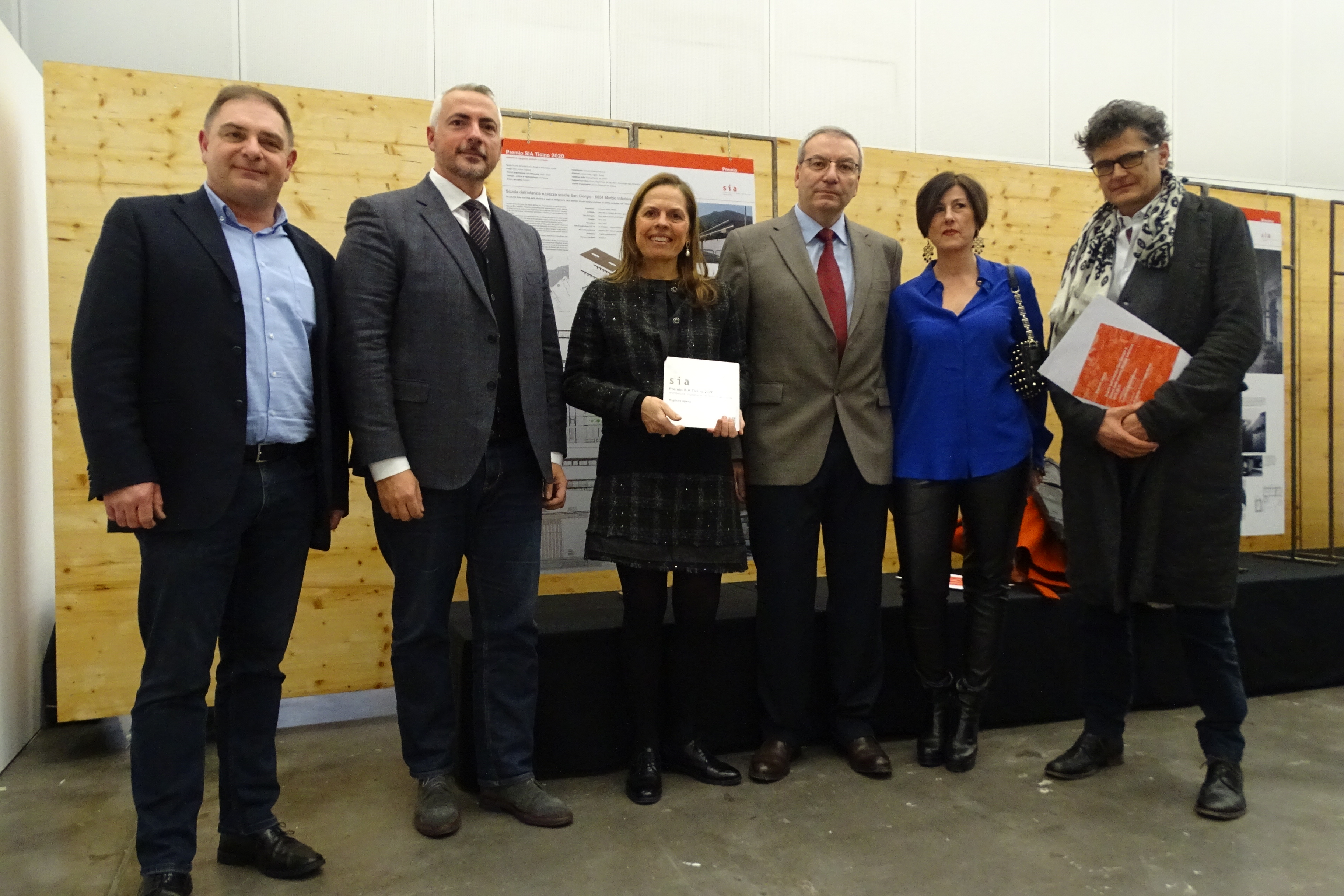 Da sinistra, Paolo Spinedi, presidente di SIA Ticino, Daniele Caverzasio, presidente della giuria, e i vincitori del premio per la miglior opera: i rappresentanti del Comune di Morbio Inferiore e l'architetto Jachen Könz.