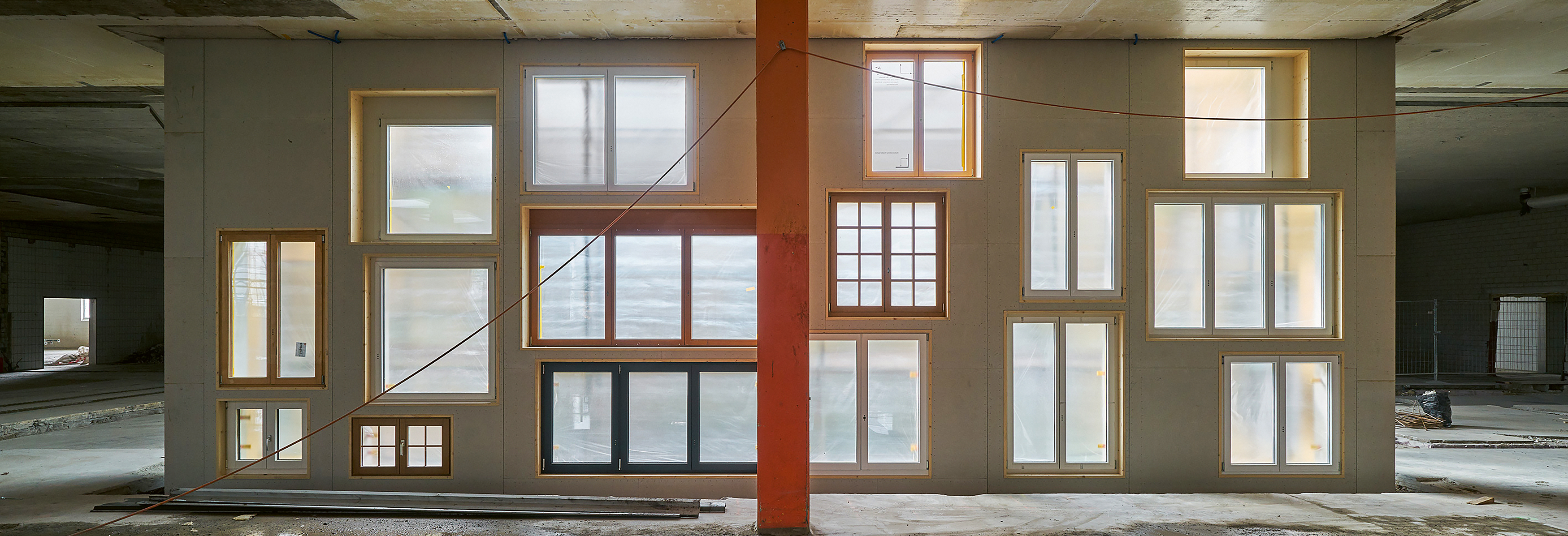 Die Fassade des Innenhofs im Basler Lysbüchel-Areal wurde vom Baubüro in situ mit Fenstern aus Über- oder Reservebeständen von rund zehn Schweizer Fensterbauern erstellt. Hätte man sie hier nicht verwendet, wären sie als Sperrgut entsorgt worden. Foto: Martin Zeller Die Fassade des Innenhofs im Basler Lysbüchel-Areal wurde vom Baubüro in situ mit Fenstern aus Über- oder Reservebeständen von rund zehn Schweizer Fensterbauern erstellt. Hätte man sie hier nicht verwendet, wären sie als Sperrgut entsorgt worden. Foto: Martin Zeller