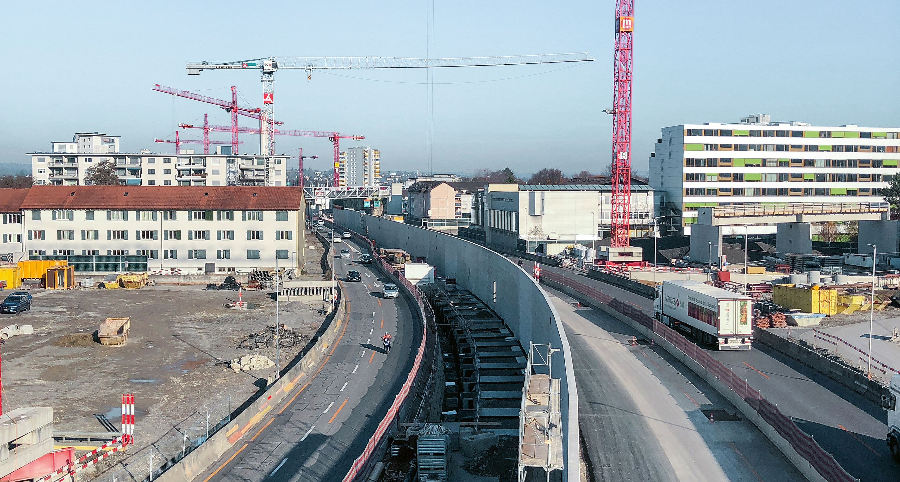 Blick Richtung Osten auf die Baustelle. Die Mittelwand der Einhausung steht bereits. Die Installationsflächen der Strassenbaustelle sind nicht zu unterschätzen.
