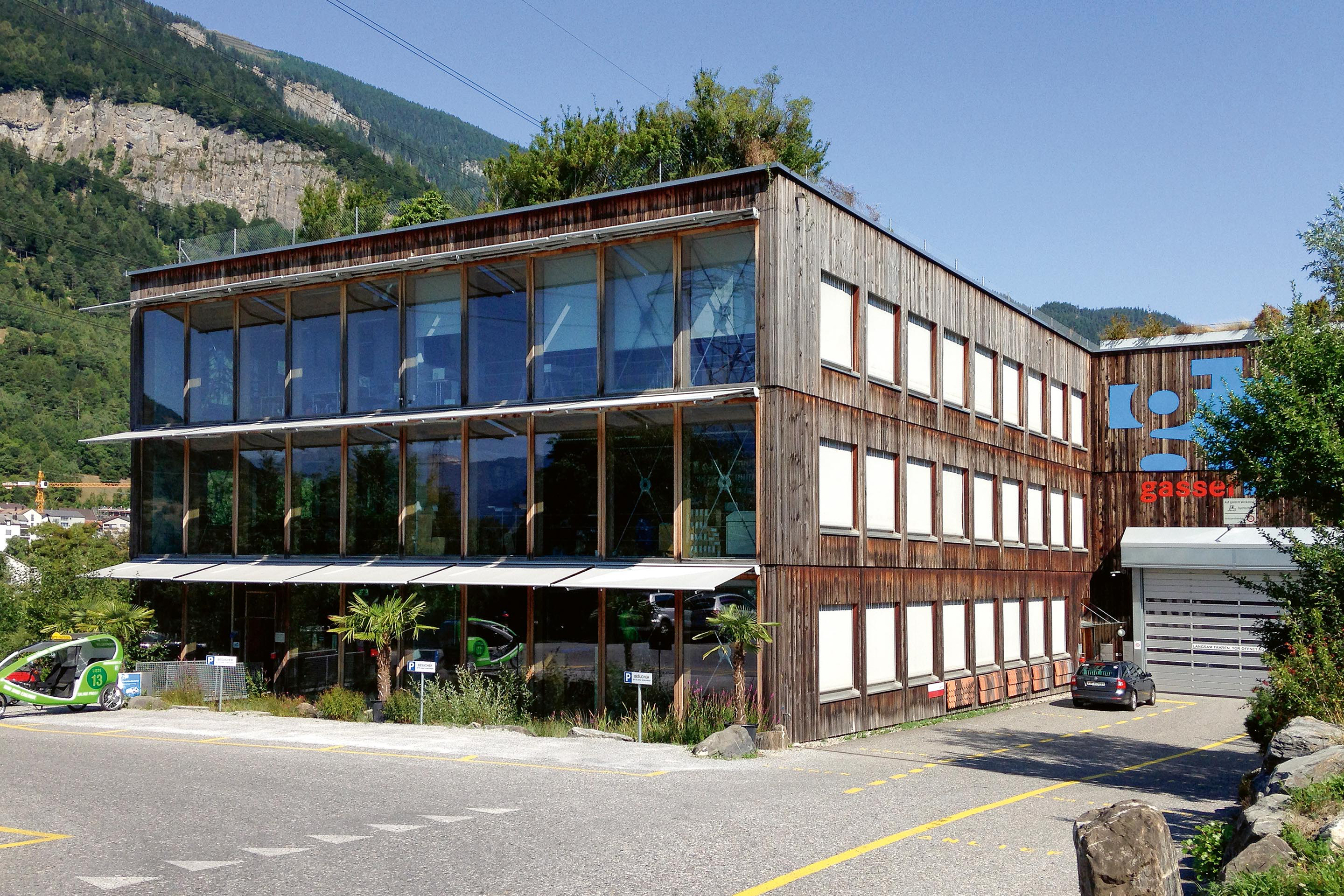 Mit dem Bürobau für den Baustoffhandel Gasser in Haldenstein machten die Prinzipien der Triner Solarhäuser – Solarfassade (ganz oben), Speichermasse, Isolierung – den Sprung in den grossen Massstab.
