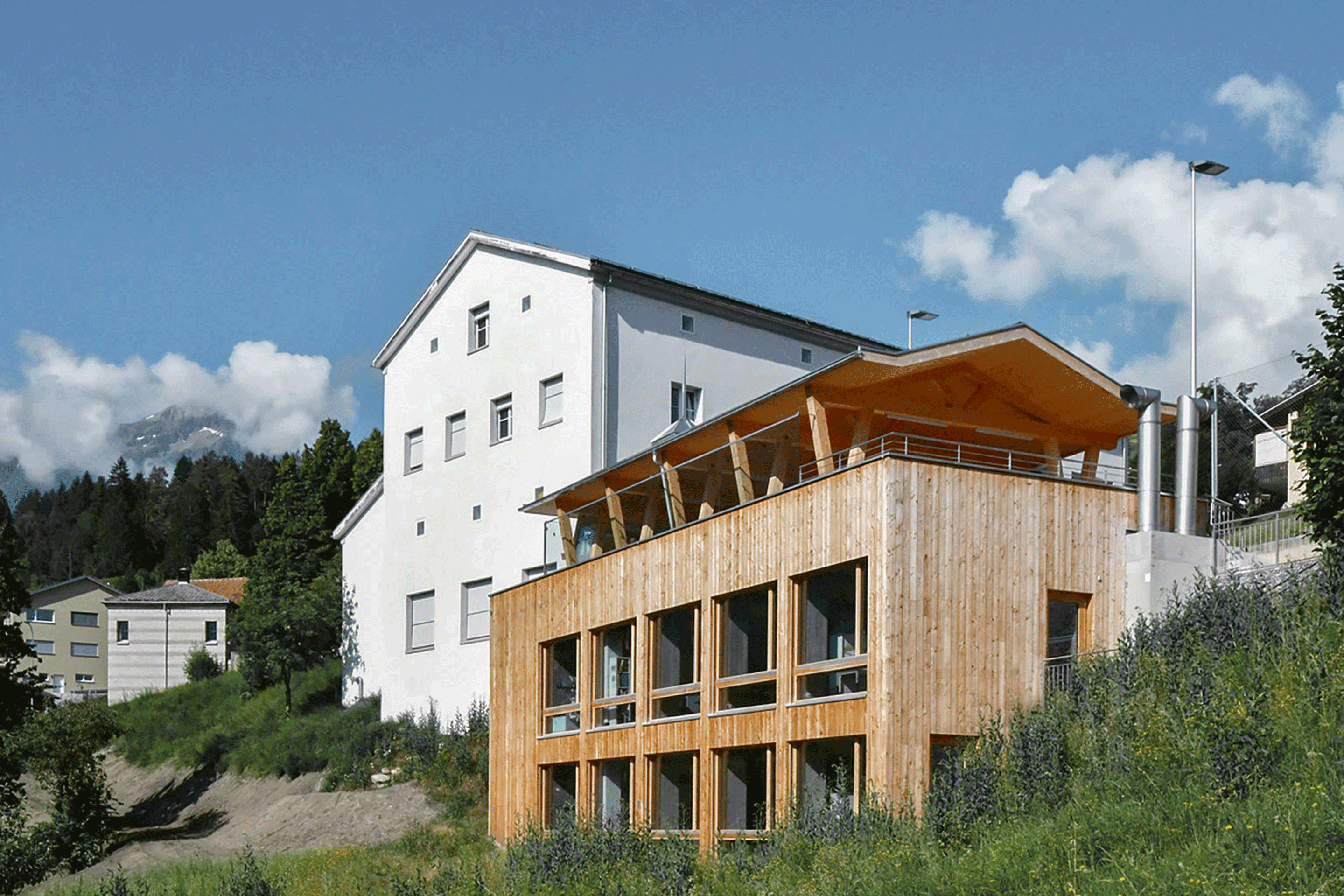 Das von Andrea Rüedi und Ueli Soom gemeinsam entworfene Schulhaus Masein fügt sich in seine dörfliche Umgebung und proklamiert nicht überdeutlich, dass es sich um einen Bau mit solarem Direktgewinn handelt.