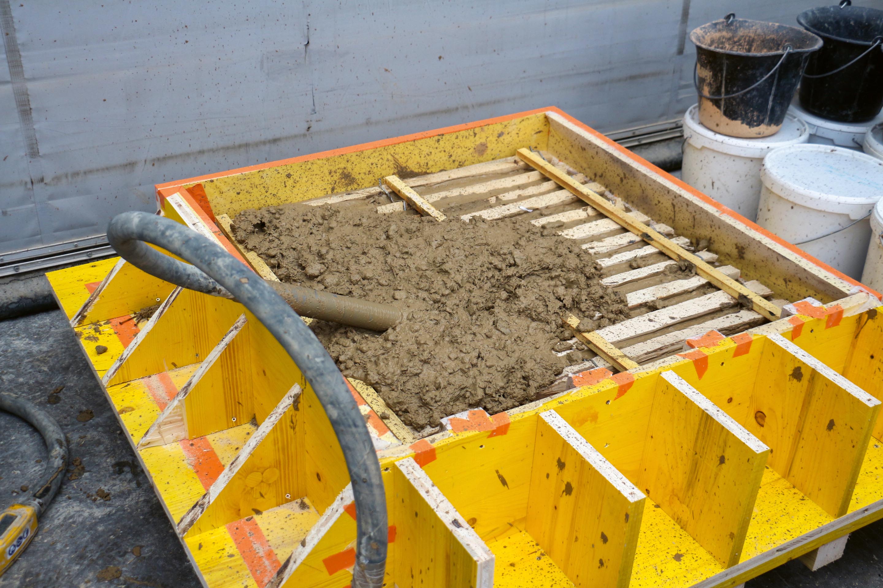 Médiathèque Jean Quarré: coffrage pour terre coulée à plat dans des cages d’armatures en bois, tests