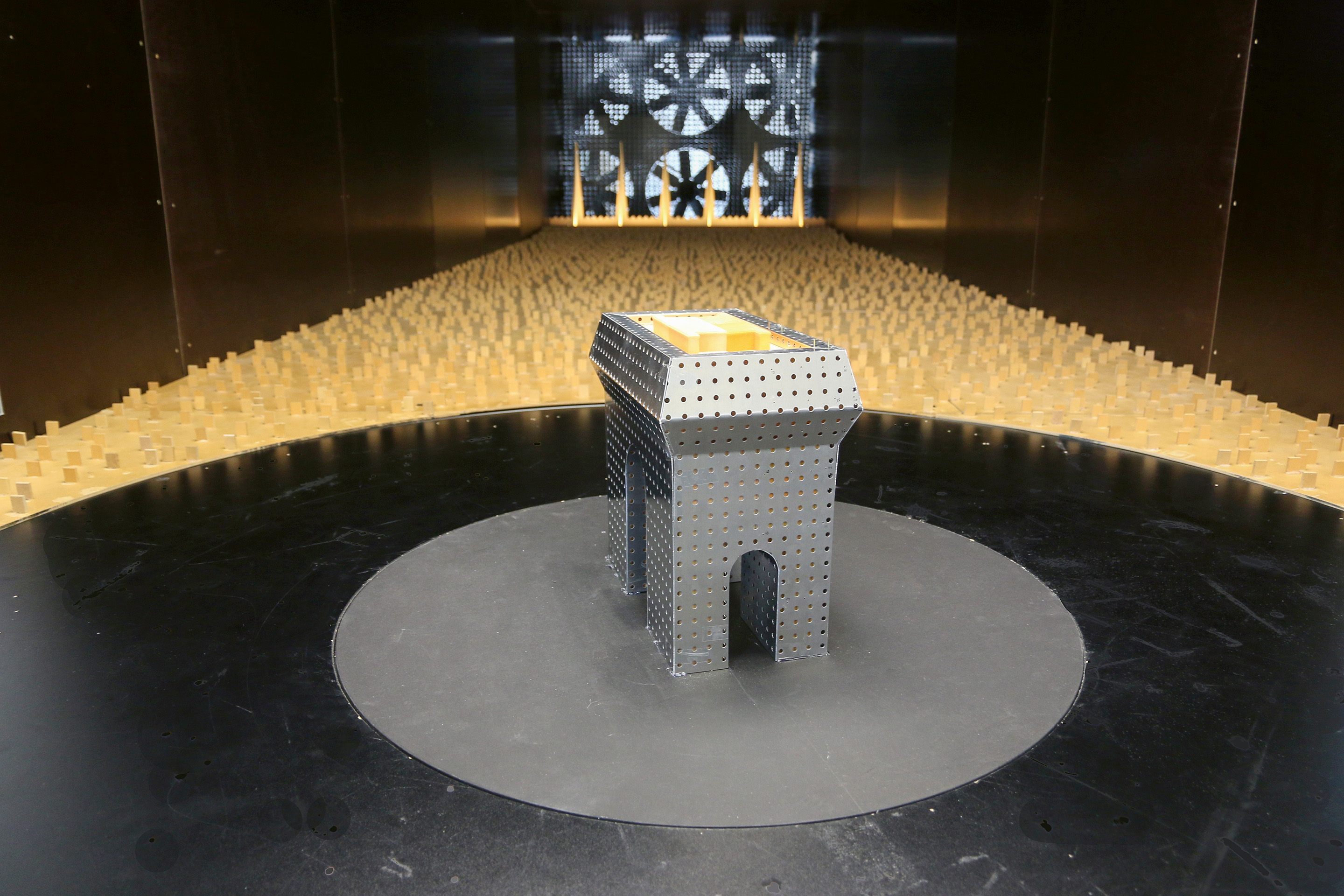 Skaliertes Modell (1:150) im Windkanal, als «Verhüllungsstoff» diente eine Metalllochplatte. Die Lochfläche entsprach dabei der Durchlässigkeit des vorgesehenen Gewebes.