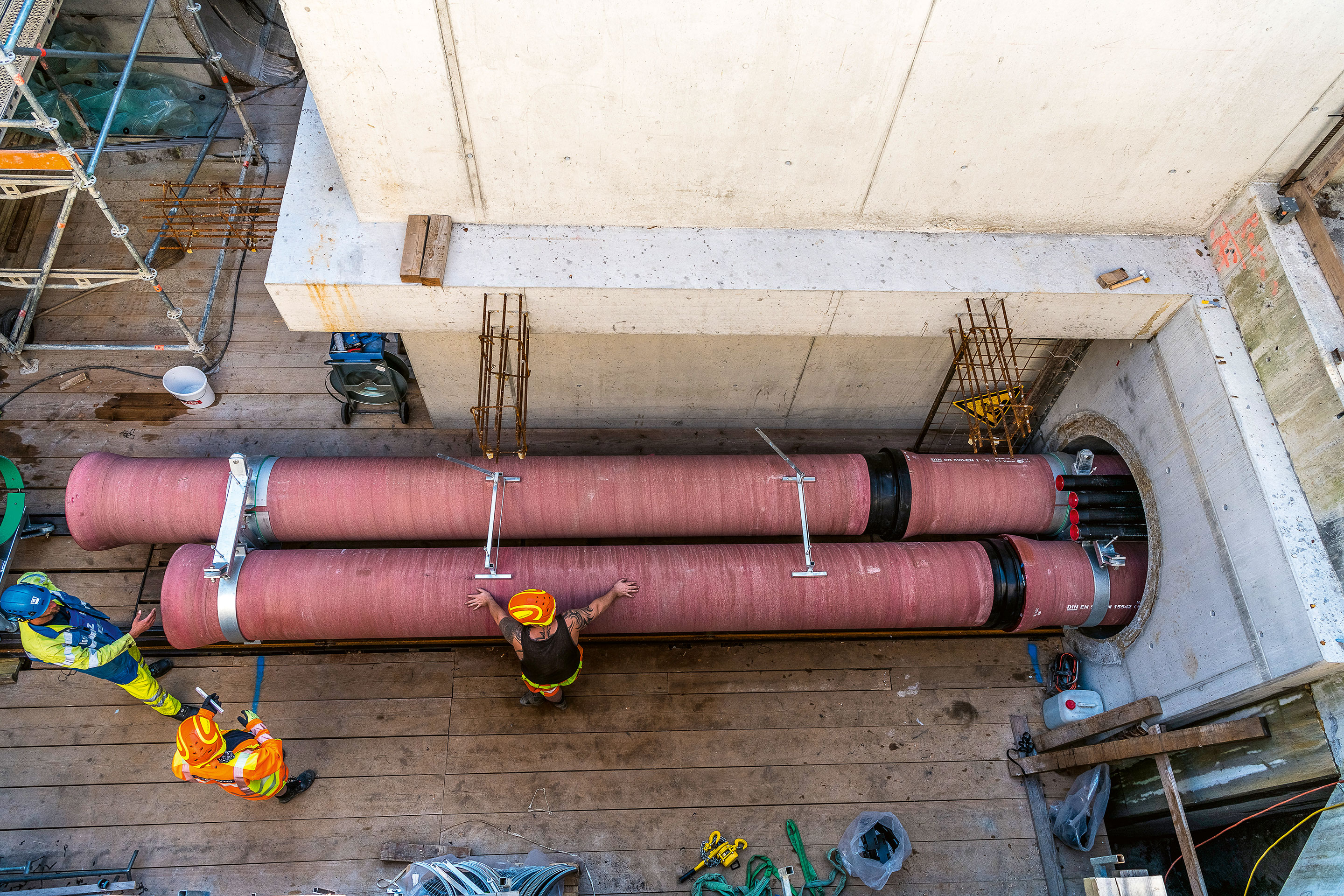 Condotte in ghisa DN600 di mandata e ritorno della rete Circulago, Inserimento simultaneo nel tunnel di 1.6m di diametro interno, effettuato mediante una speciale pinza mobile per tubi doppi realizzata appositamente in acciaio V4A.