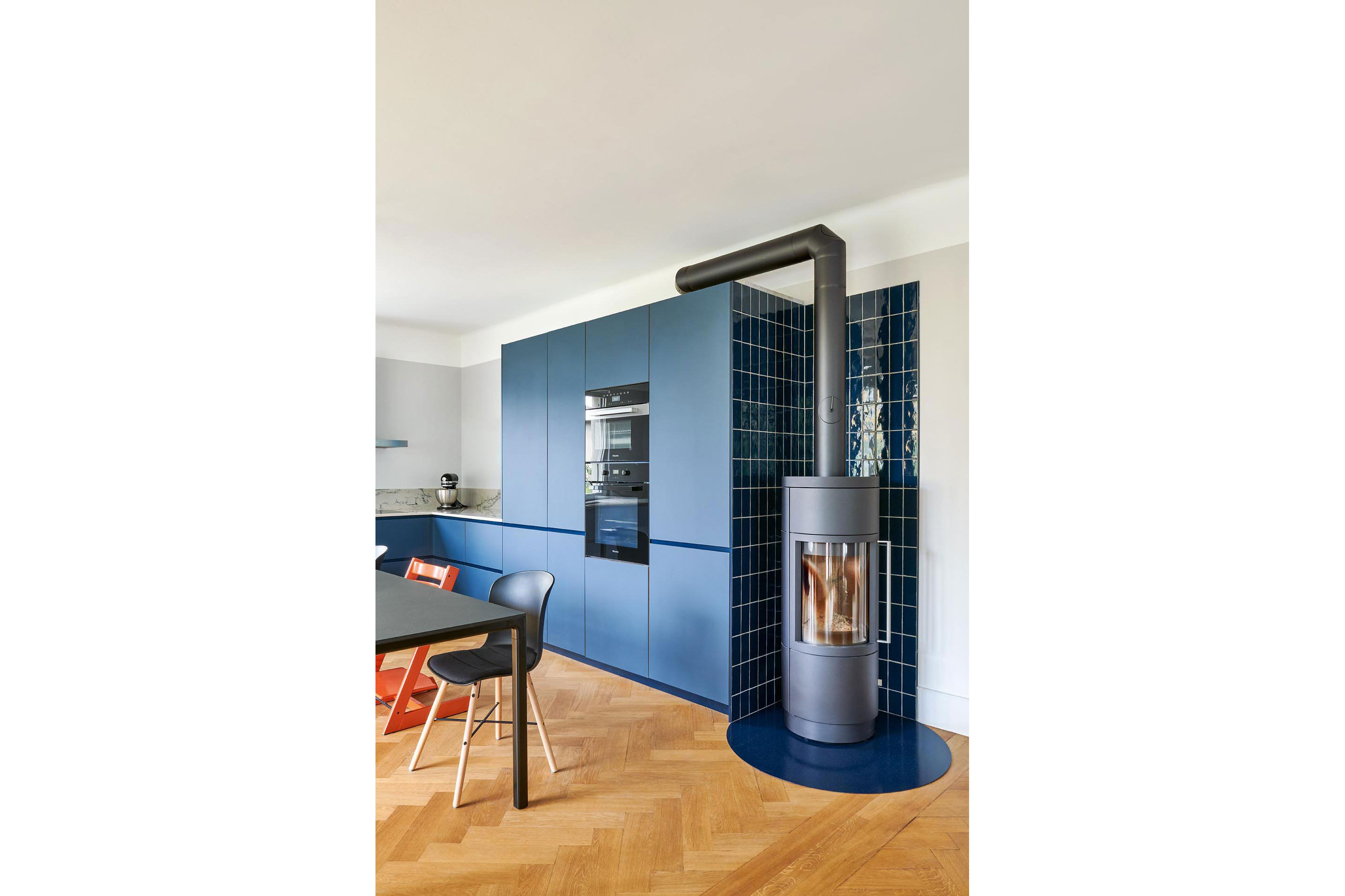 Holzöfen heizen die Innenräume, ergänzt mit einem zentralen Pelletkessel sowie Solarthermie und Photovoltaik auf dem Dach.