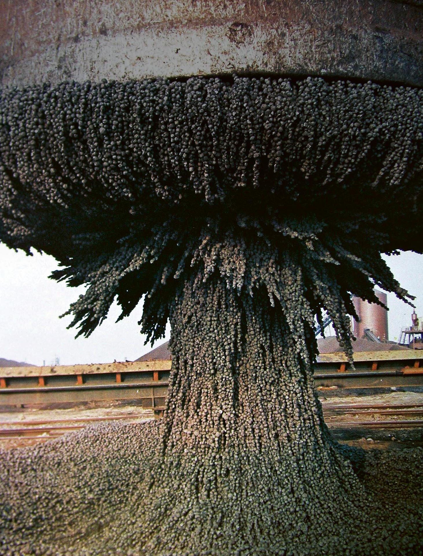 Eisenschwamm (Direct Reduced Iron)  wird mit einem Elektromagneten in die Höhe gehoben. Erzeugt wird er in der Direkt­reduktionsanlage von ArcelorMittal  in Hamburg – heute noch mit Erdgas,  in Zukunft mit Wasserstoff.