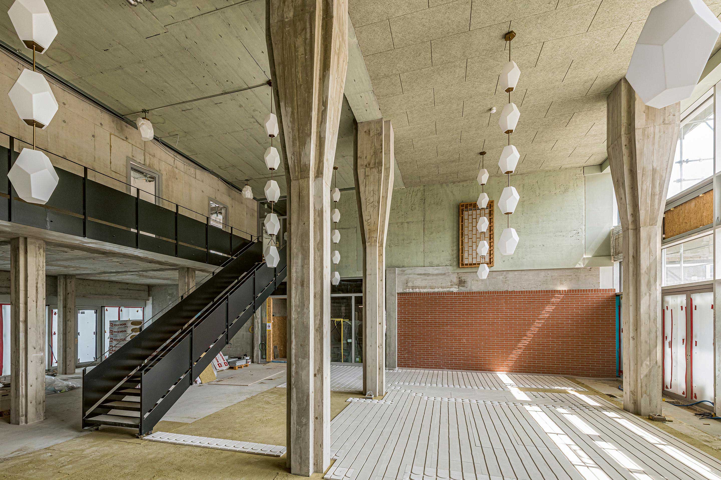 Die neue Eingangshalle stellt den stärksten Eingriff in die Bausubstanz des ehemaligen Felix Platter-Spitals dar. Vom neu ge­schaffenen zweigeschosshohen Entrée erreicht man entweder die «Rue intérieure», an der die Erdgeschossnutzungen angeschlossen sind, oder man begibt sich über die erste der einläufigen Treppen auf die Tour durch das zentrale Innere des Gebäudes.