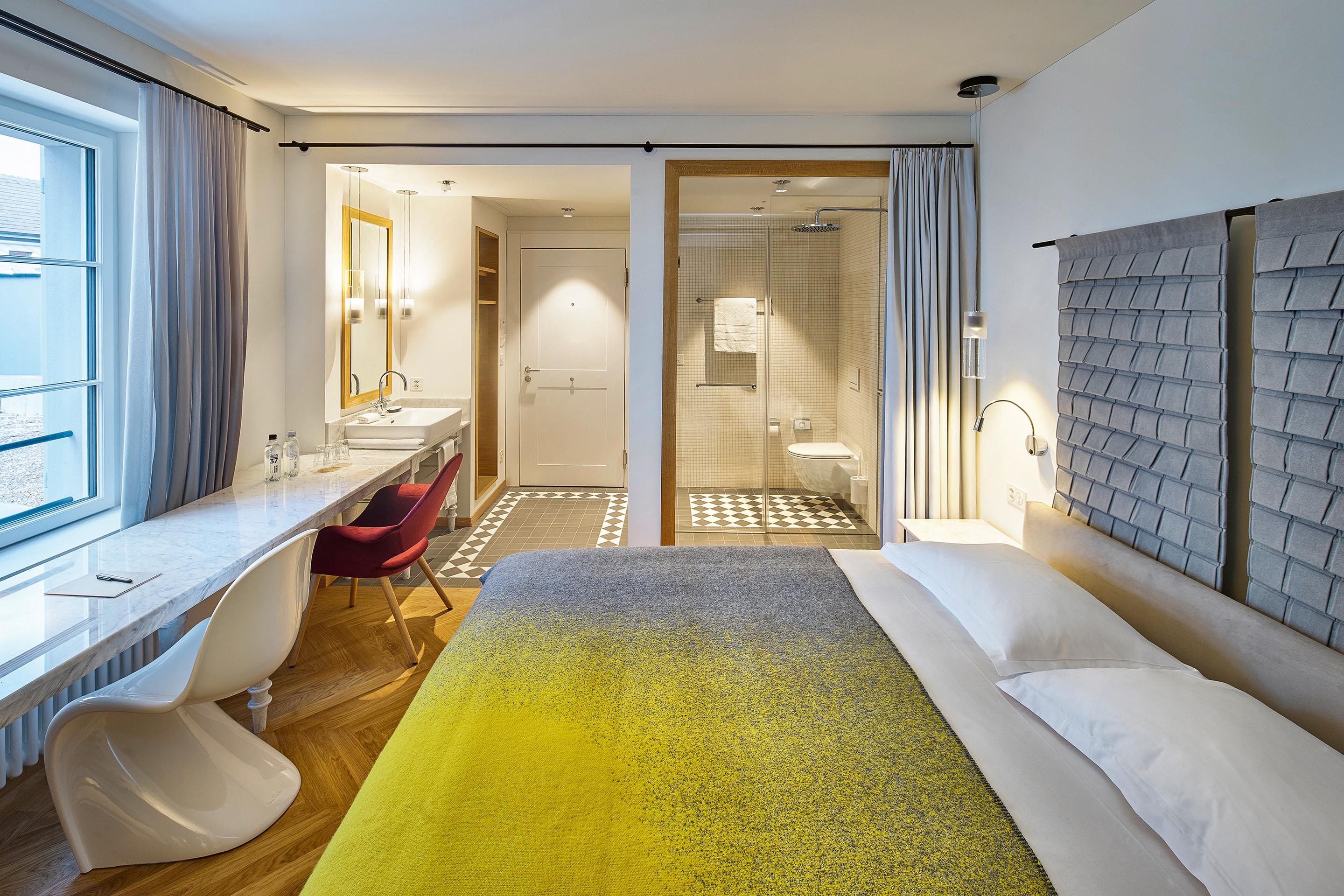 Lustvolle Spielereien: Lange Marmortische mit gedrechselten, marmorisierten Holzbeinen treffen im Hotel Adler  auf Designklassiker.