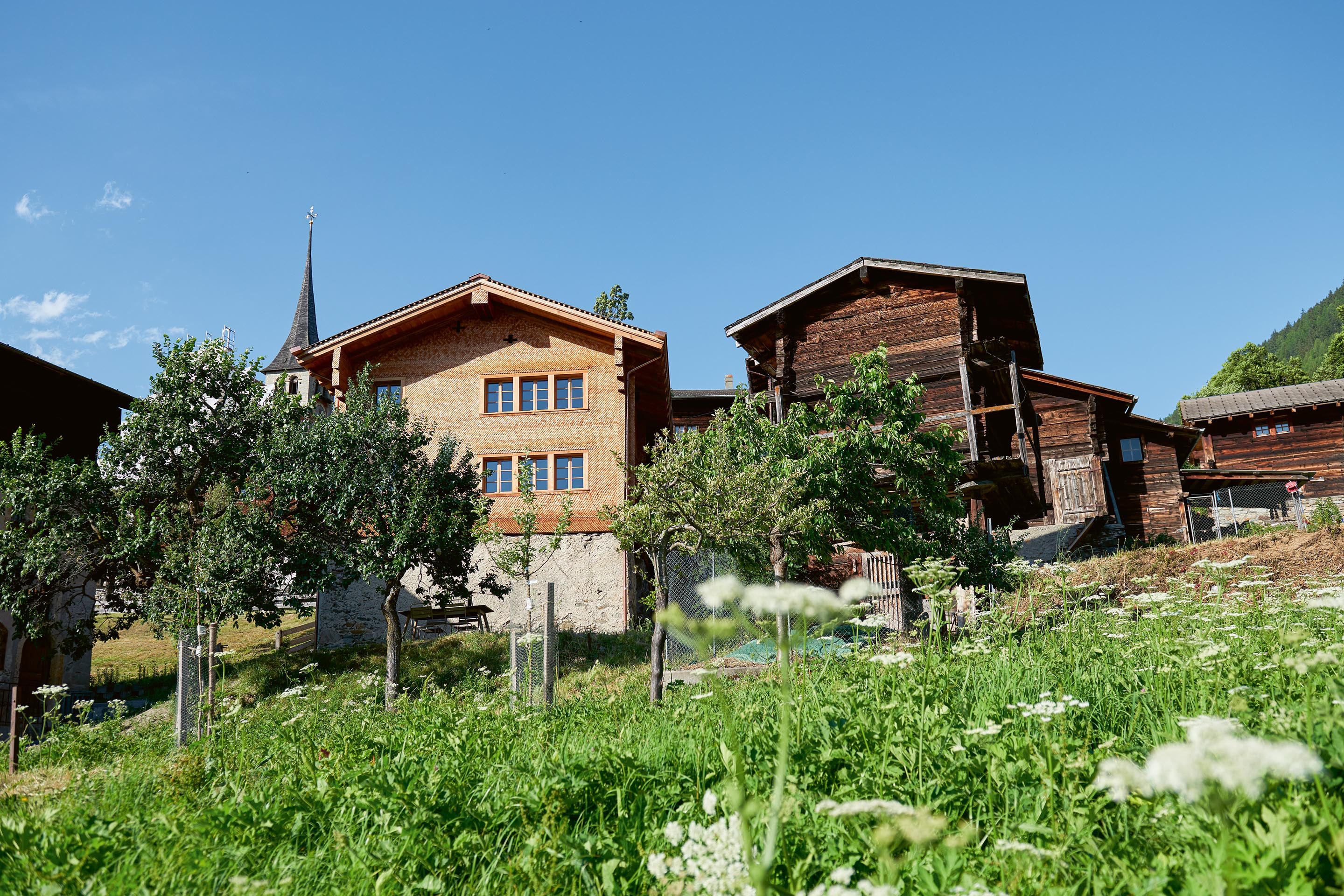 Das erhaltenswerte «Hüs uf der Flüe» in Ernen befindet sich in der vom Kanton bewilligten Kirchen-Schutzzone und durfte deshalb aussen nur beschränkt verändert werden. Abgottspon Werlen Architekten fügten an der Seite zwei Fenster zu einem einzelnen alten hinzu, sodass eine Dreierreihe entstand. Aufwendig war auch die ganz neu geschindelte Fassade.