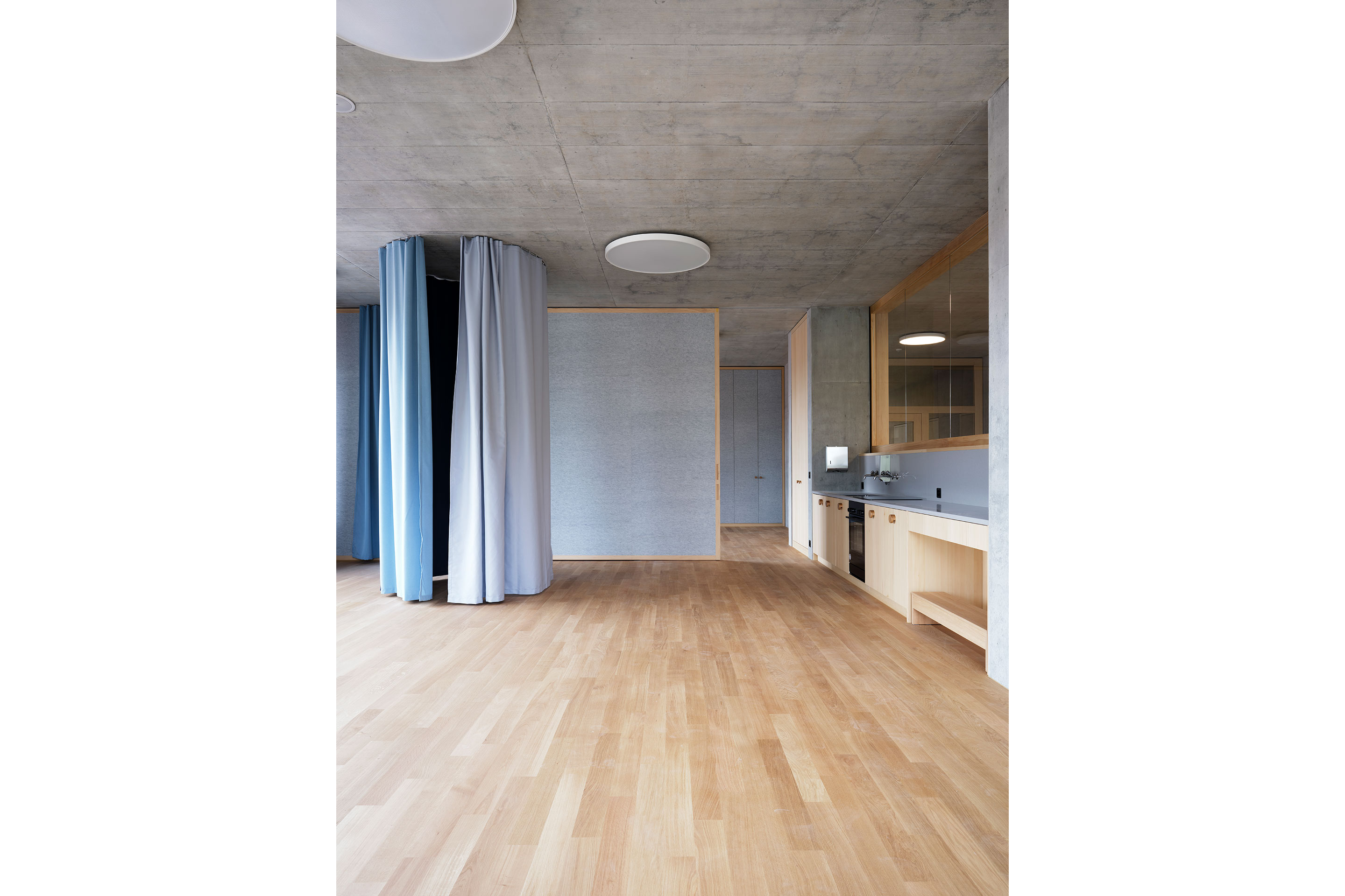 Hinter einem Vorhang im Kindergarten, der im zugezogenen Zustand eine Schneckenform bildet, können die Kinder «Verstecklis» spielen.