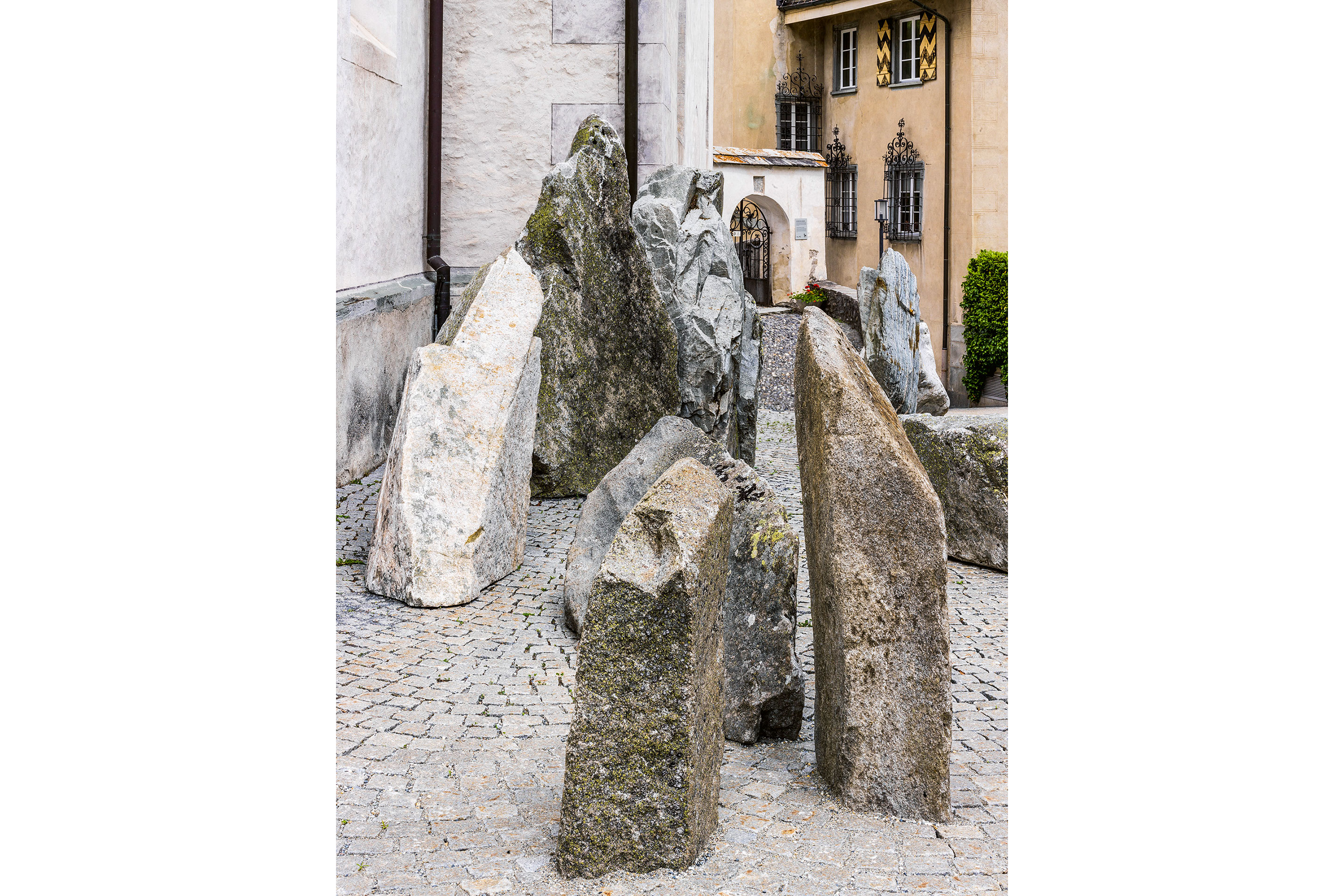 Versammlung von Sedimentgesteinen der Helvetischen Decken mit älteren Graniten und Gneisen vor der reformierten St.-Margarethen-Kirche.
