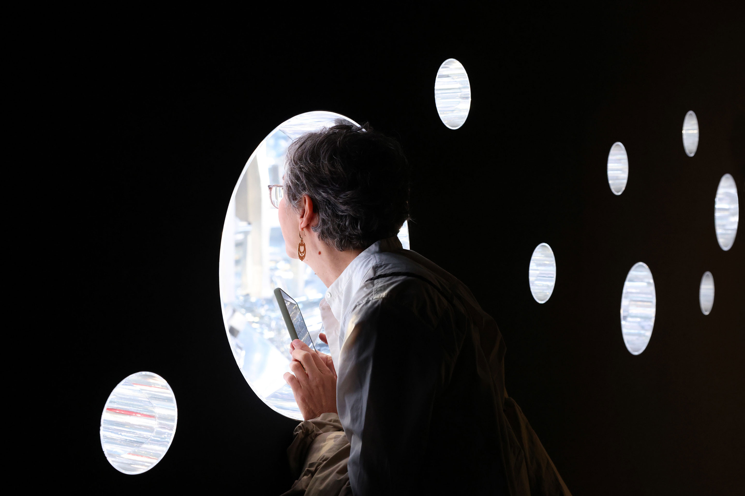 Eine Wand im letzten kleinen Raum lockt mit runden Ausschnitten, die den Blick in das Kaleidoskop erlauben.