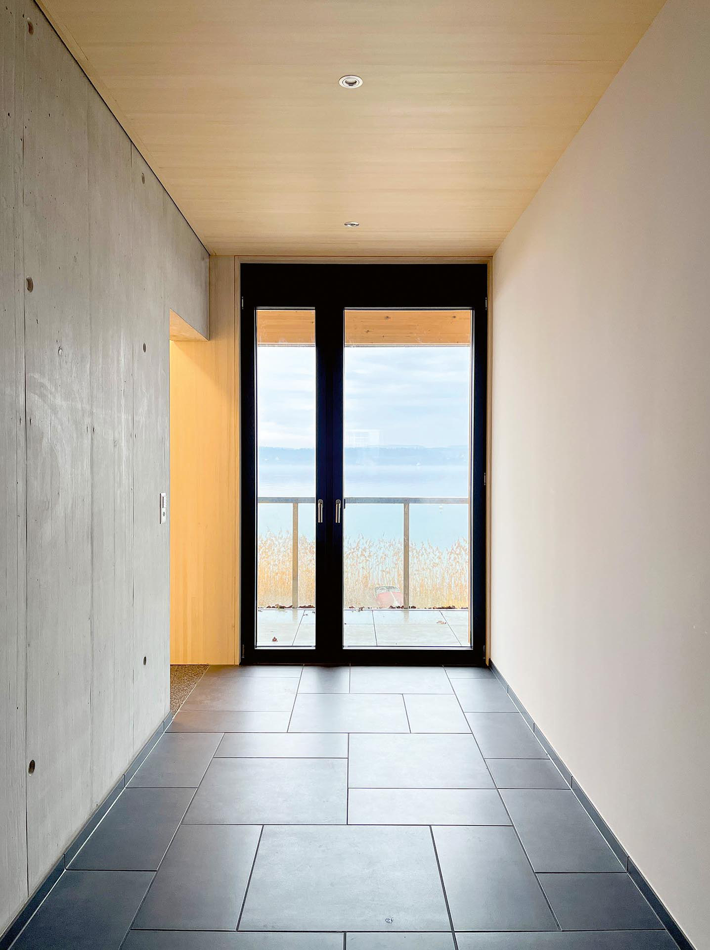 Die hybride Konstruktion in Holz und Beton begünstigt die passive Wärmespeicherung. Nur nach Norden, zum Zürichsee hin, sind die Balkongeländer transparent.