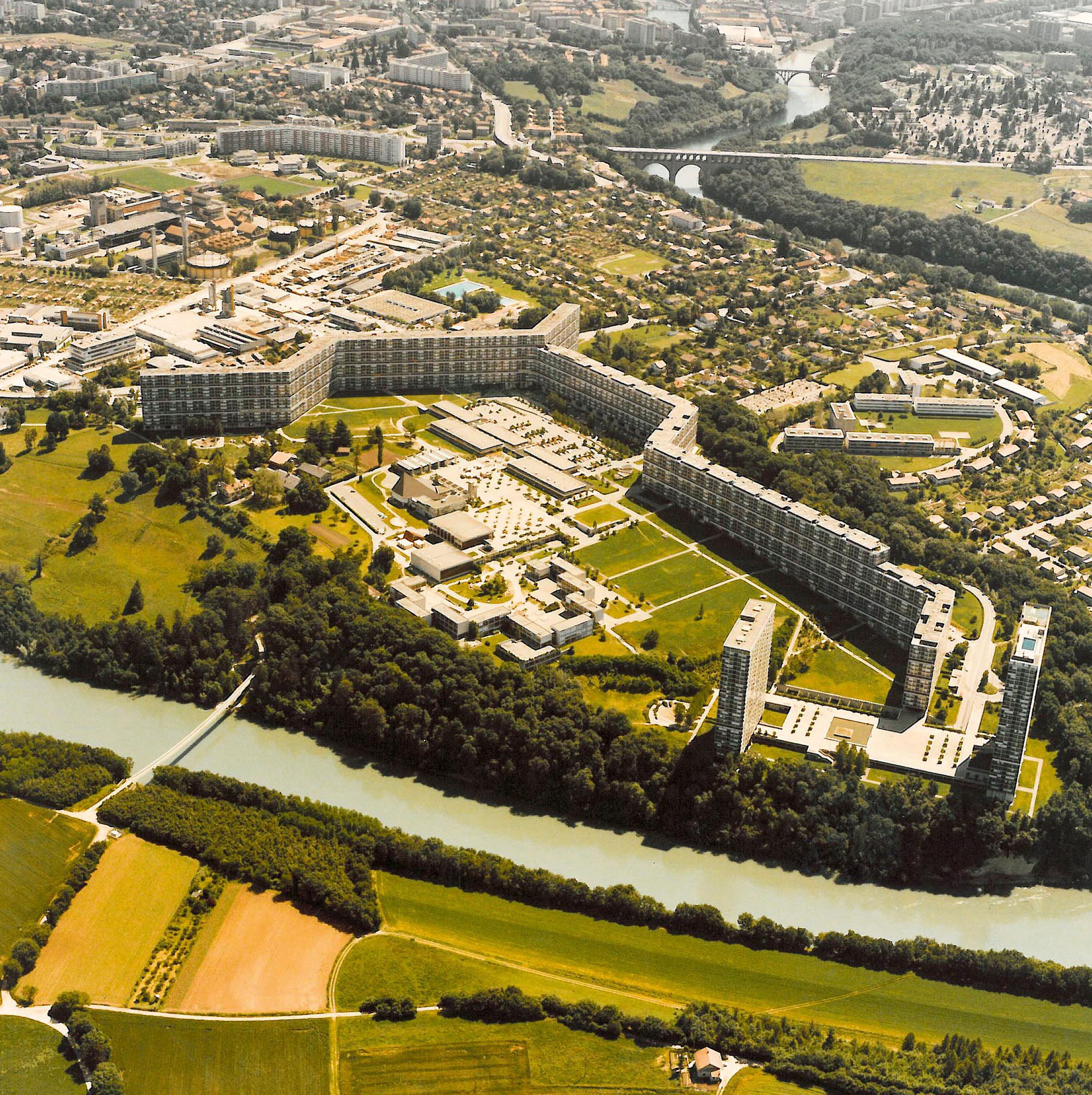 Photo aérienne de la cité du Lignon, construite entre 1963 et 1971 par les architectes Georges Addor, Jacques Bolliger, Dominique Julliard et Louis Payot. Ce n’est pas le premier exemple de barre pliée à Genève: elle s’inscrit dans la lignée de l’opération immobilière du Parc de Vermont, des architectes A. Bordigoni, J. Gros et A. de Saussure.
