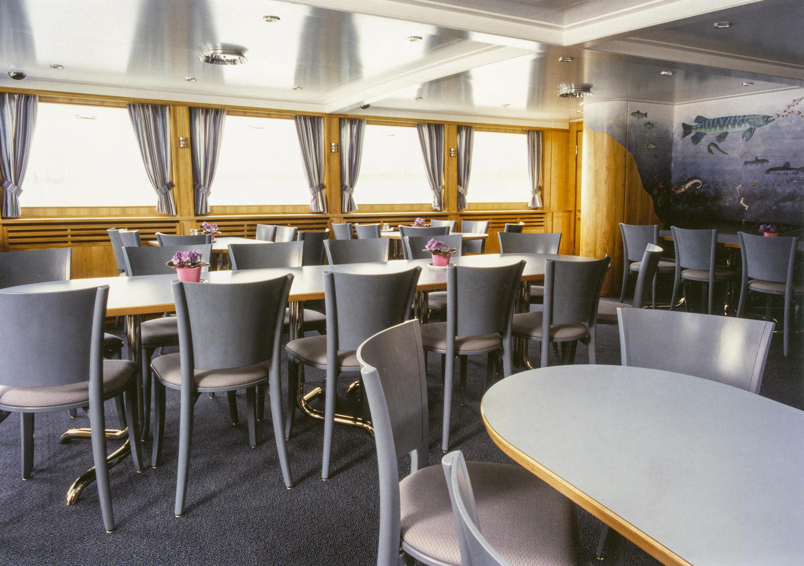 Farblich bewegt sich die Möblierung zwischen dem unaufgeregten Graublau, das so typisch für die dunstige Seelandschaft ist und klar behandelten Holzeinbauten. (Renovierung «MS Zürich» der SBB Bodenseeflotte, 1988).