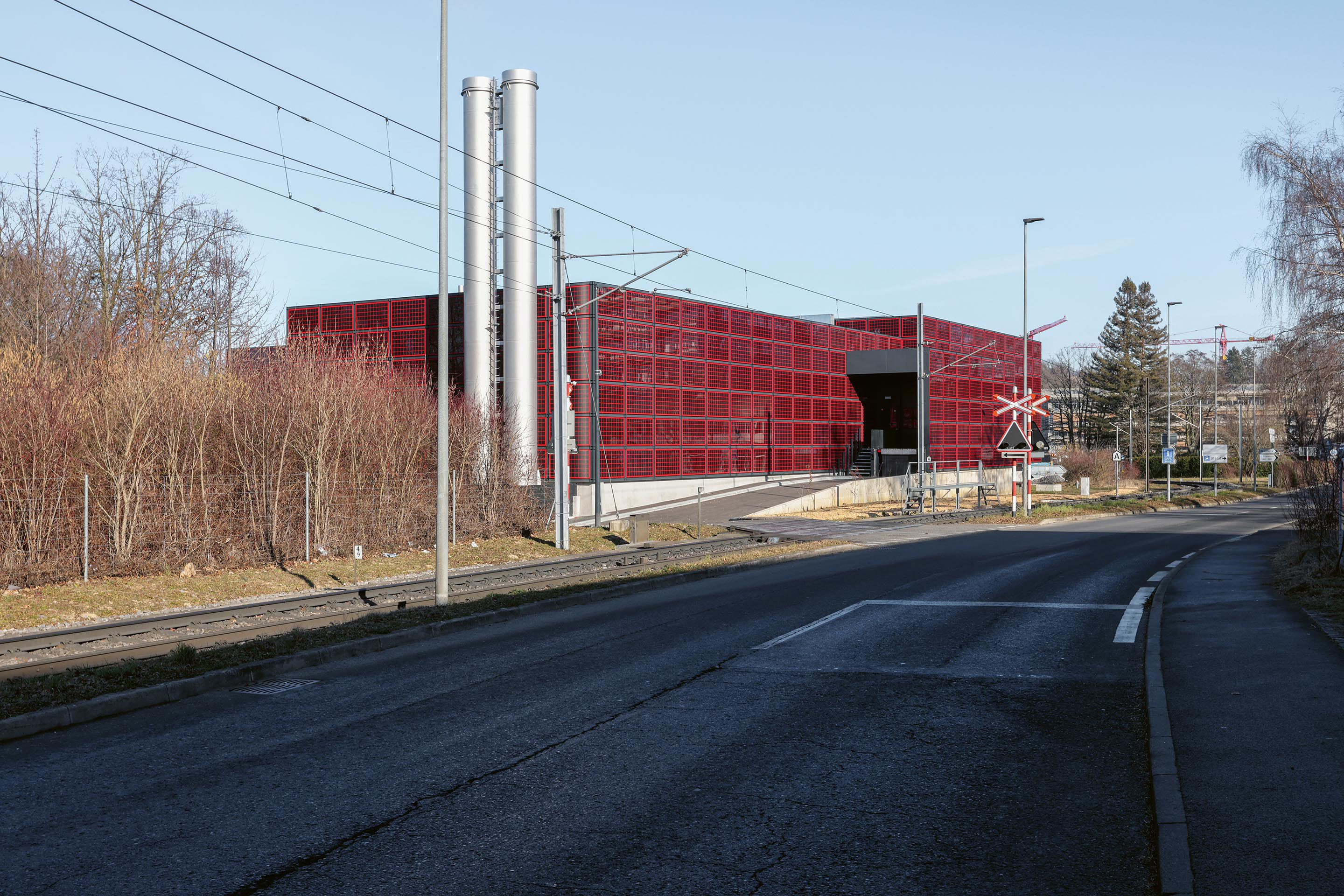 Die neue Heizzentrale der EPFL ist mit Photovoltaikpaneelen verkleidet und beinhaltet neben Wärmepumpen auch eine  Server­zentrale, um die darin anfallende Abwärme nutzen zu können. Die Schornsteine gehören zu zwei Gasturbinen, die während des Baus im Einsatz waren und zukünftig bei Engpässen zur Verfügung stehen.