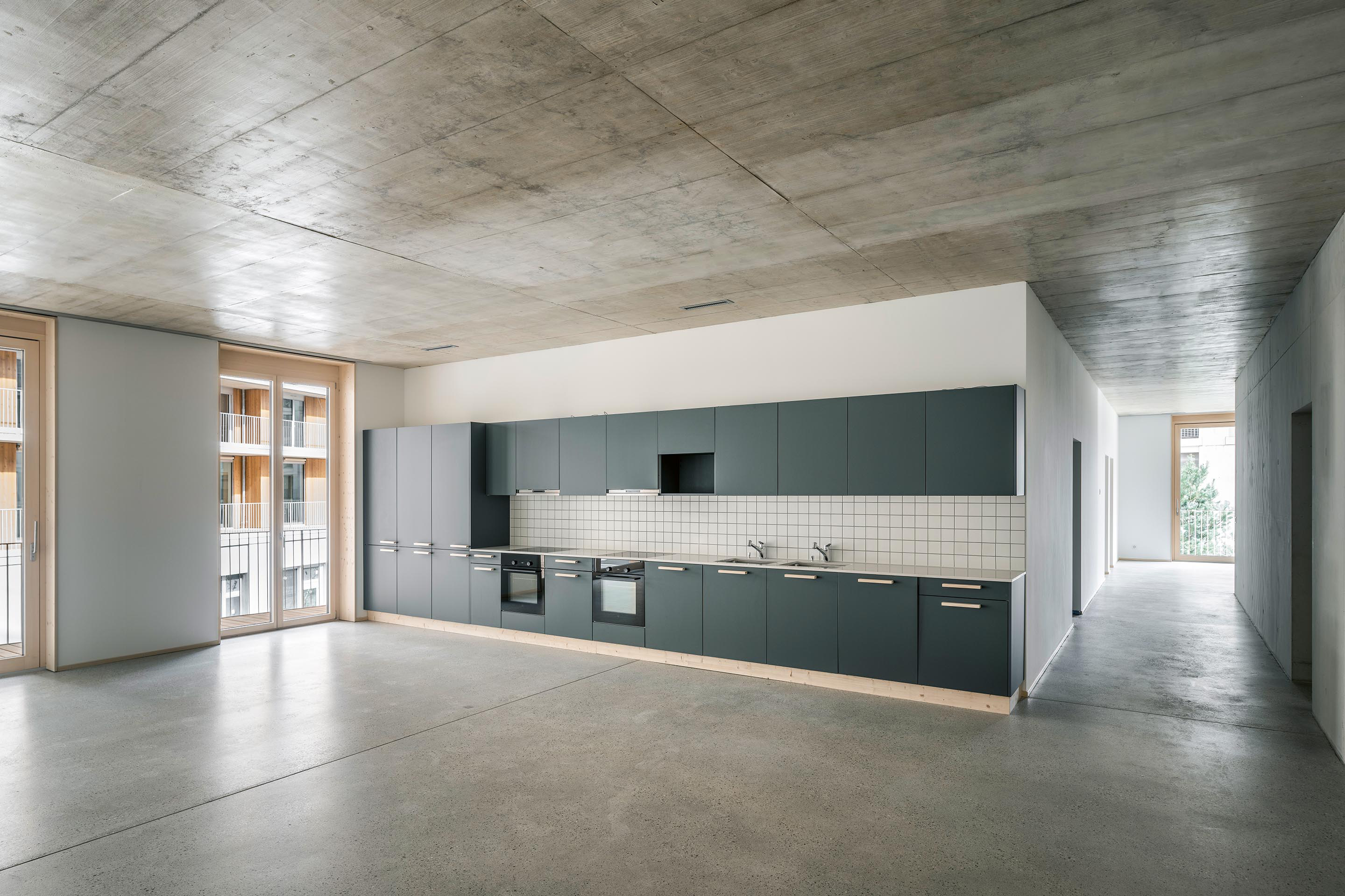 Cuisine de l’appartement en colocation (type cluster), équipée de deux cuisinière et deux grands frigos, pour les grandes tablées.