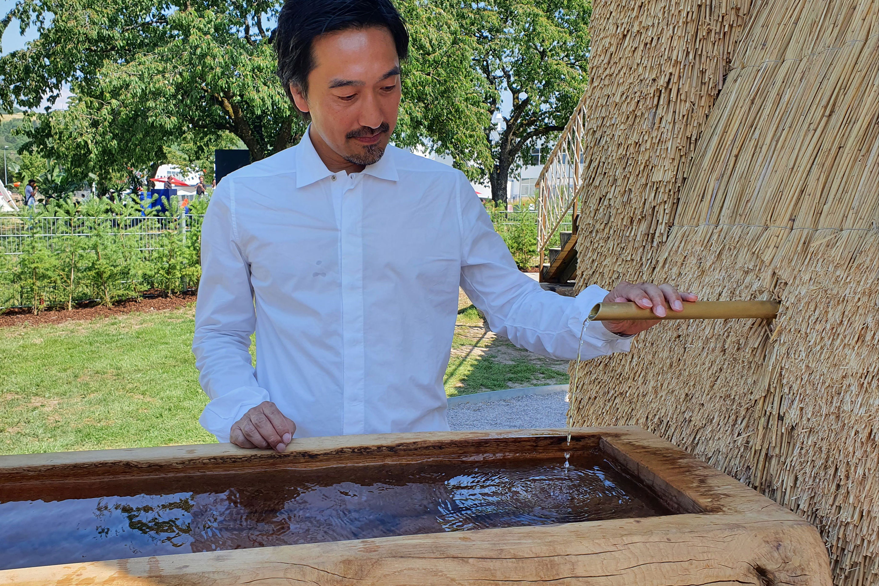 Tsuyoshi Tane kühlt sich am Brunnen