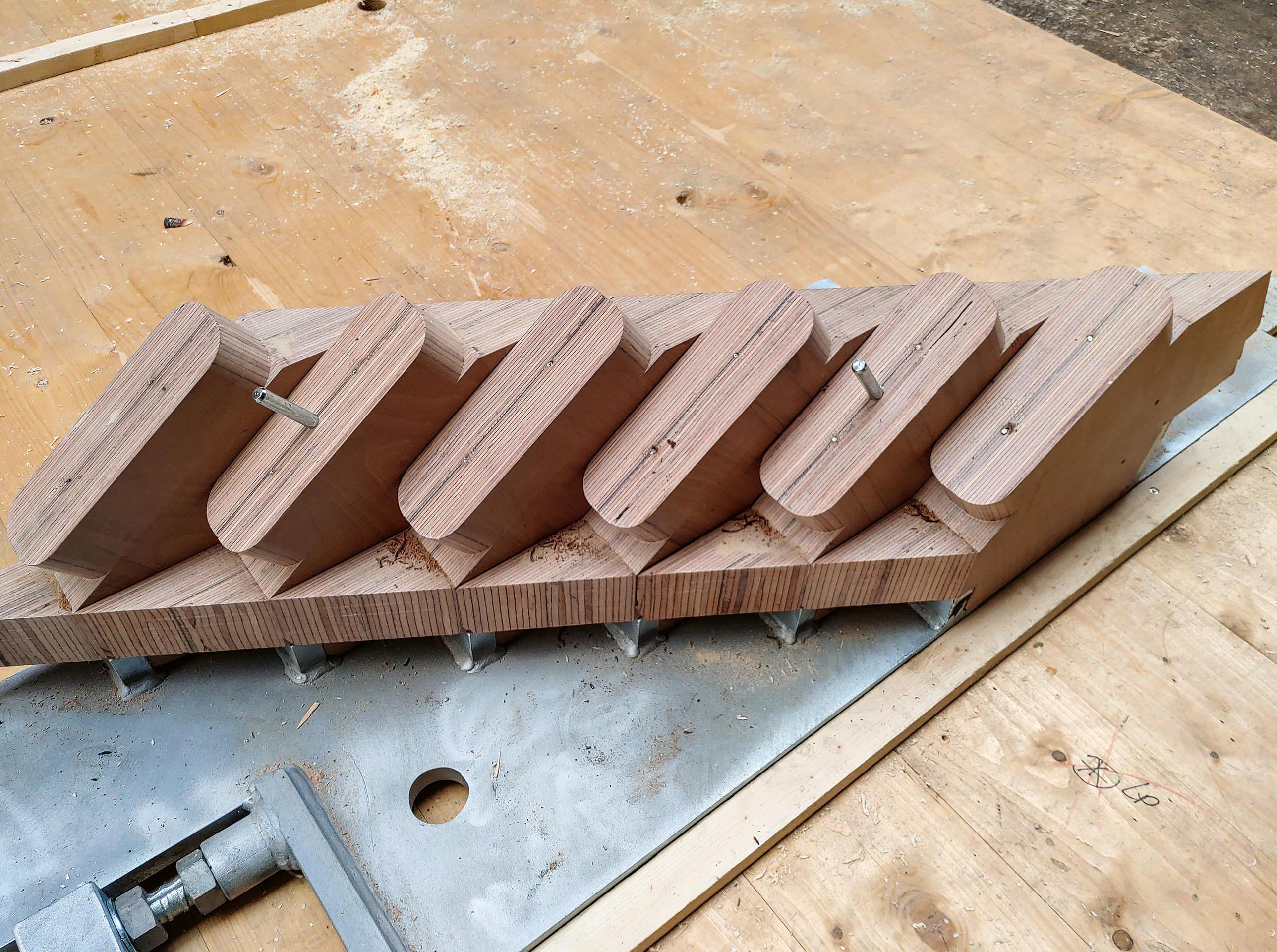 Ein mittels CNC-Technologie gefrästes BSH-Element auf einer Stahlplatte bildet die Steckverbindung zu den Fassadenelementen.