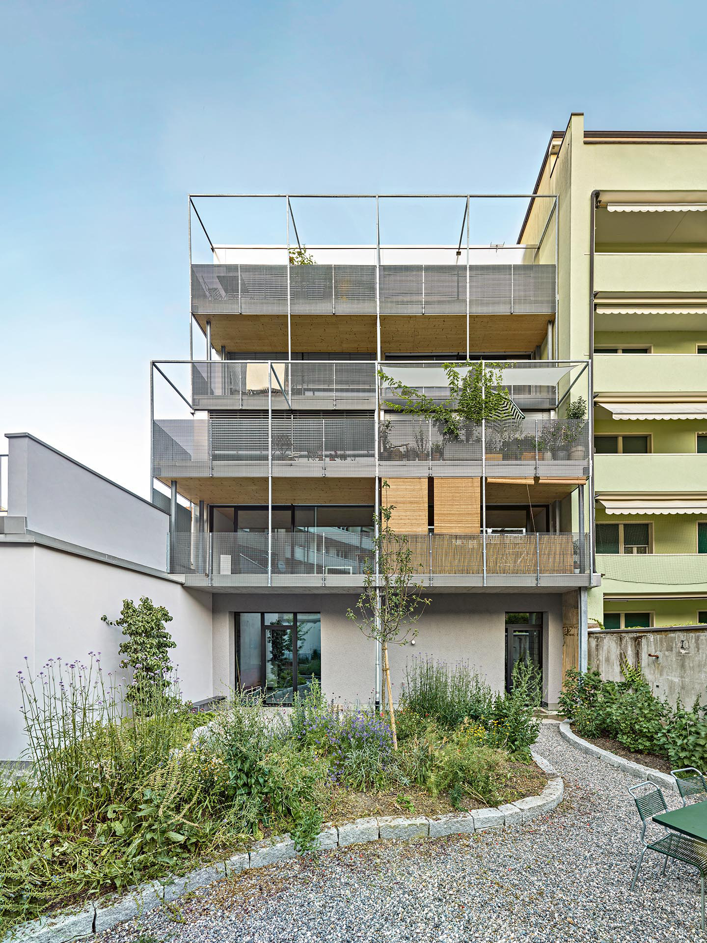 Eine Stahlbaukonstruktion mit Absturzsicherung aus ­in­dustriellen Pressrosten fasst die privaten Aussenräume ein.