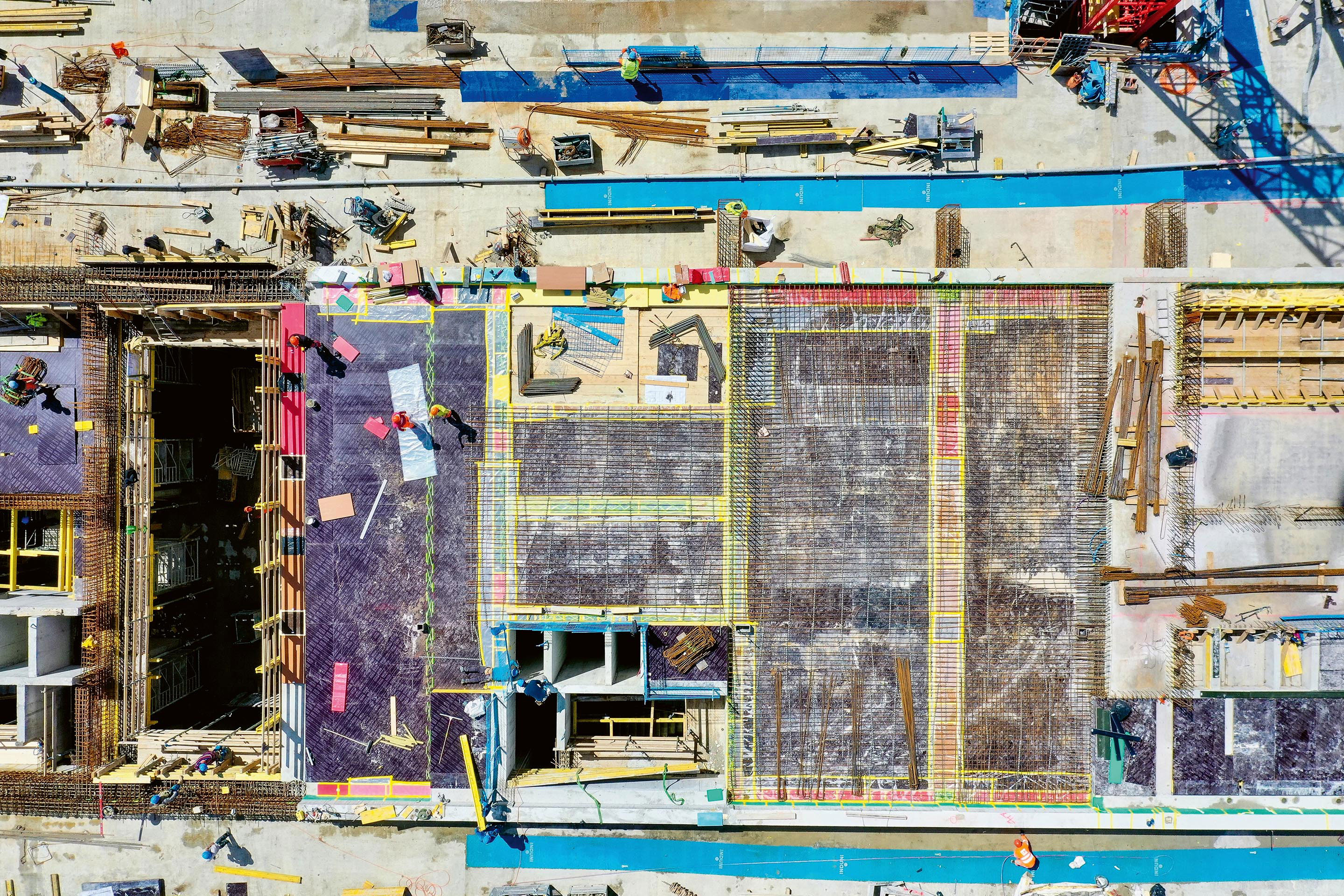 Mise en place des élastomères sur les murs du sous-sol, avant le bétonnage de la dalle du rez. Les différentes couleurs correspondent au plan de calepinage.