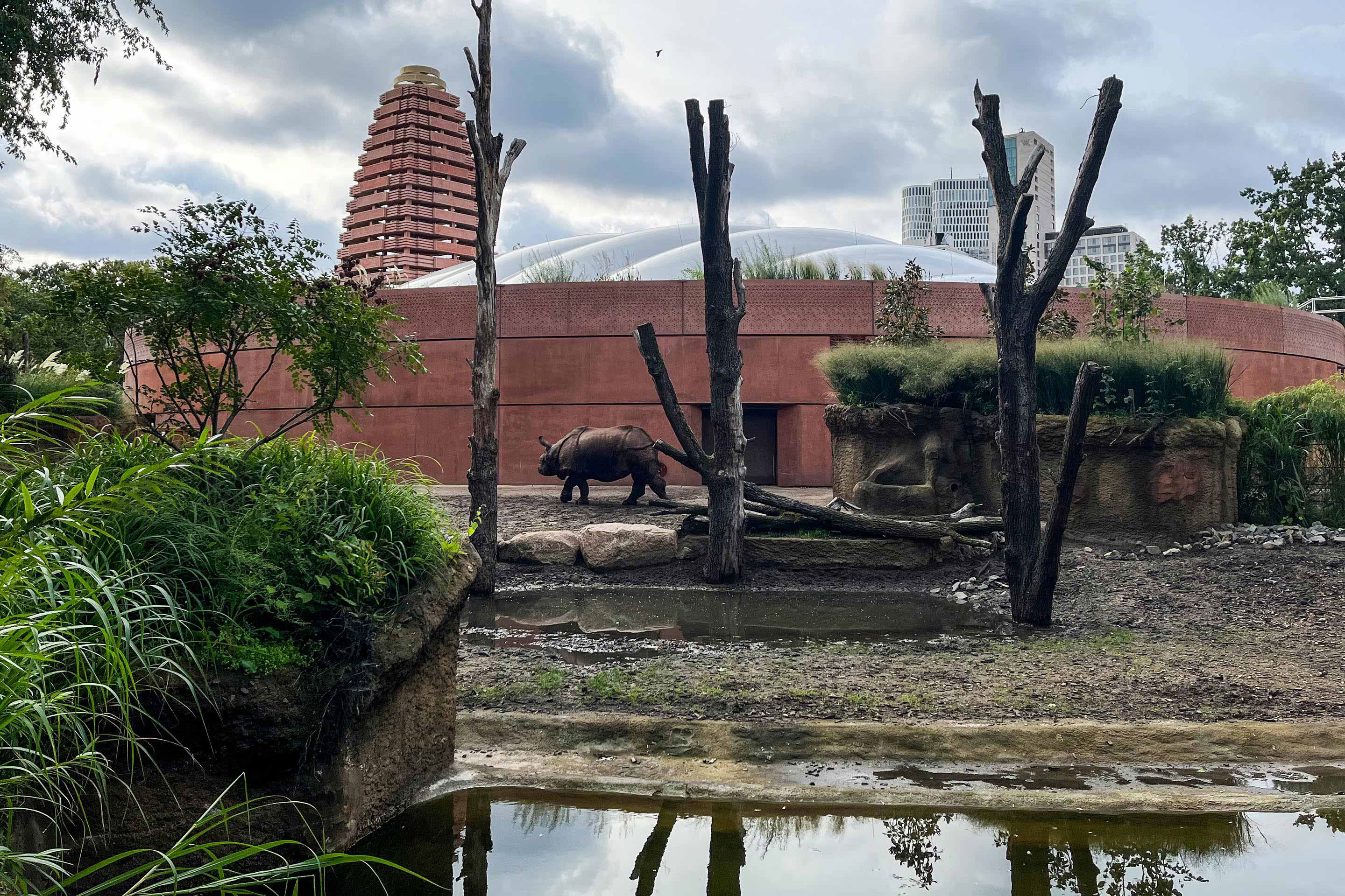 Das Gebäude besteht aus drei übereinandergestapelten Ringen: Die unteren beiden Streifen sind aus sandsteinrot gefärbtem Ortbeton, der oberste setzt sich aus kerngedämmten Betonfertigteilen zusammen. Hier ist die Dachkonstruktion verankert.