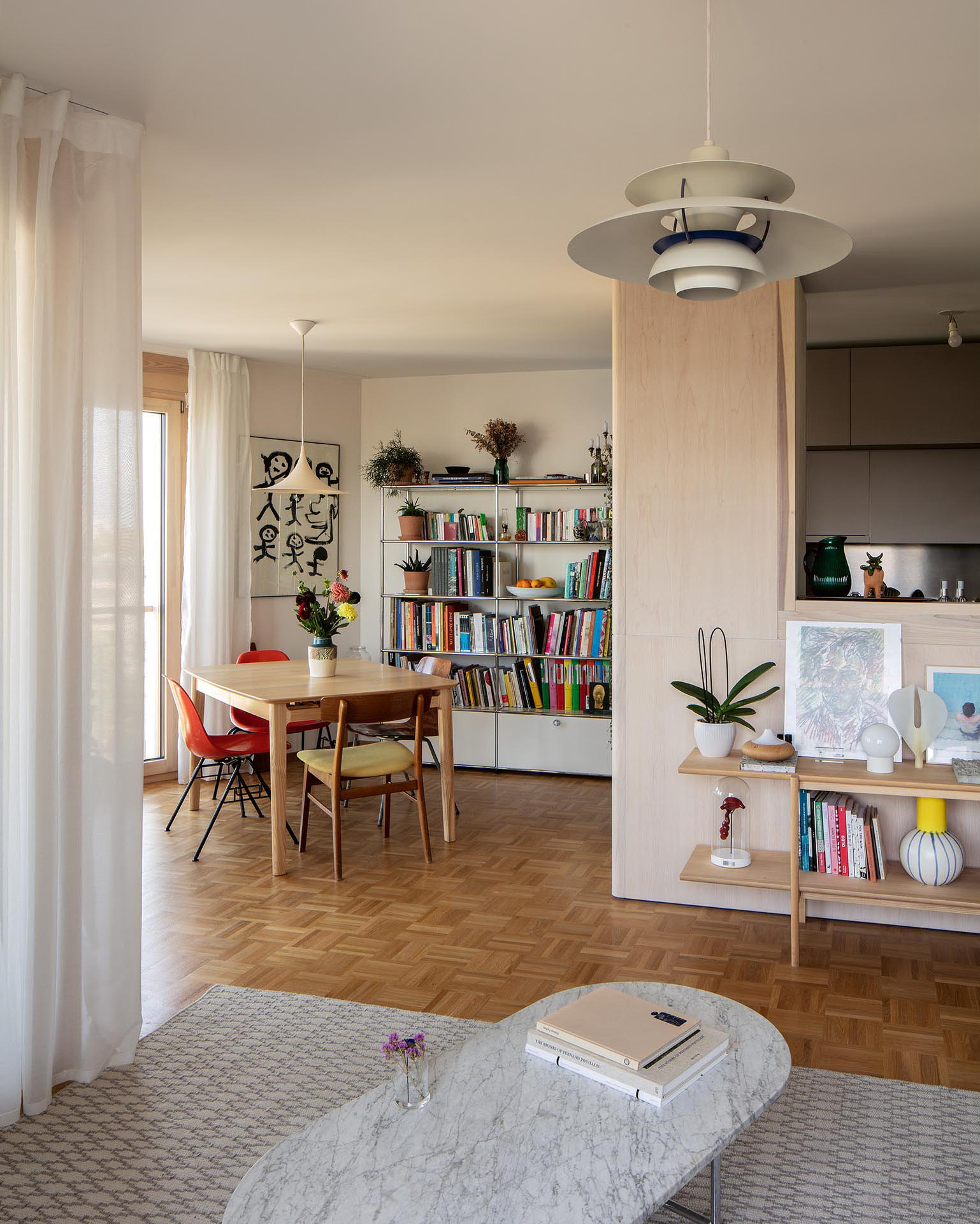 Le séjour et la salle à manger sont articulés par la cuisine, pensée comme un grand meuble, bar et point de rotation de l’appartement.