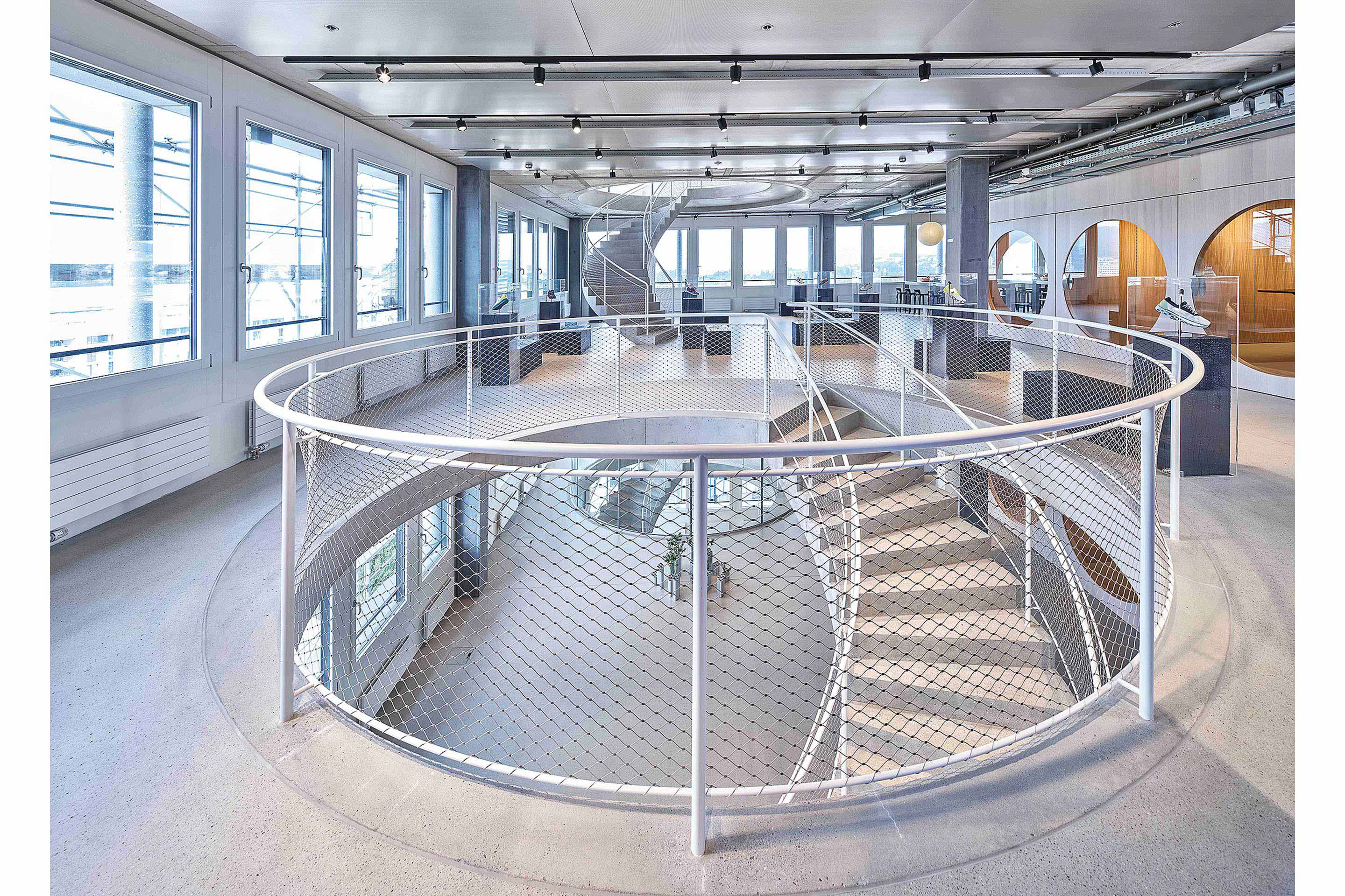 Geschwungene Sichtbetontreppen  im On Labs schaffen einen archi­tektonischen Bezug zum Fokus der Sportmarke: Bewegung.