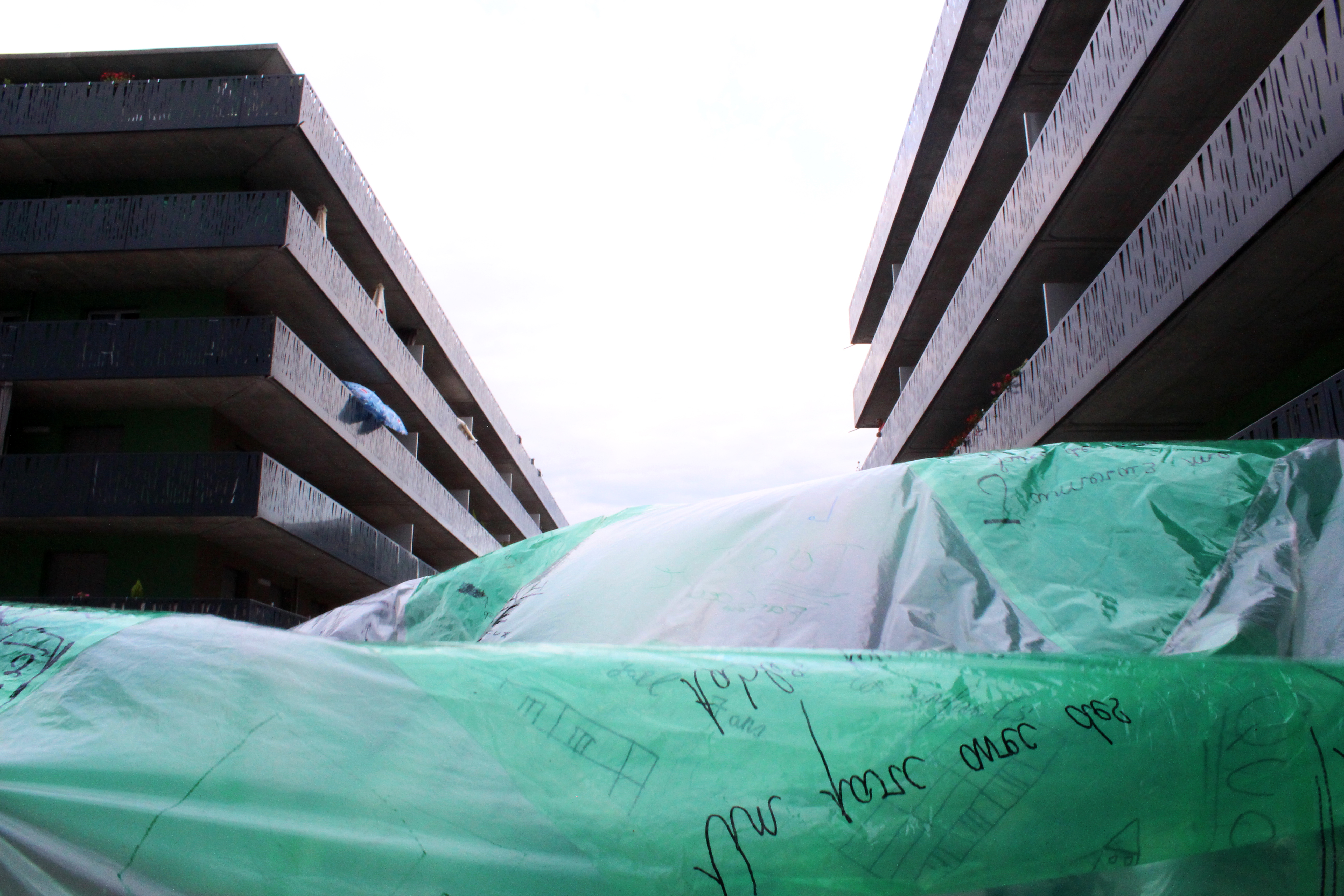 Grande Bulle à Gordon Bennett : un dispositif pour inviter les habitant·es à participer à la conception de la bulle (dessins, écriture, découpages, collage). Ils/elles ont été sollicités pour écrire sur chaque segment de plastique constituant la bulle, un mot invoquant leur rêve pour leur quartier. Dès que la bulle a été gonflée, enfants et adultes ont pu entrer et se déplacer à l’intérieur. Chacun​ ​a​ ​​​pu​ ​regarder​ ​les​ ​dessins,​ ​les​ ​rêves,​ ​les​ ​désirs​ ​sous​ ​un​ ​autre​ ​angle.