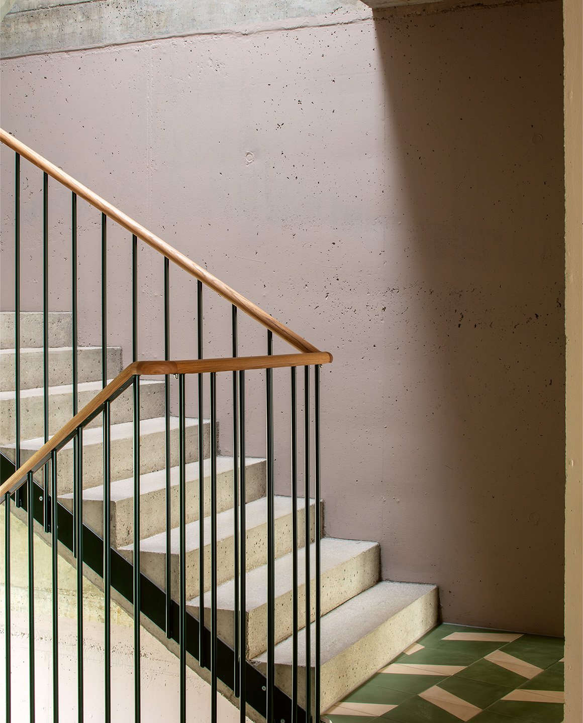 Dans la cage d’escalier de l’immeuble, les murs sont laissés bruts et simplement peints.