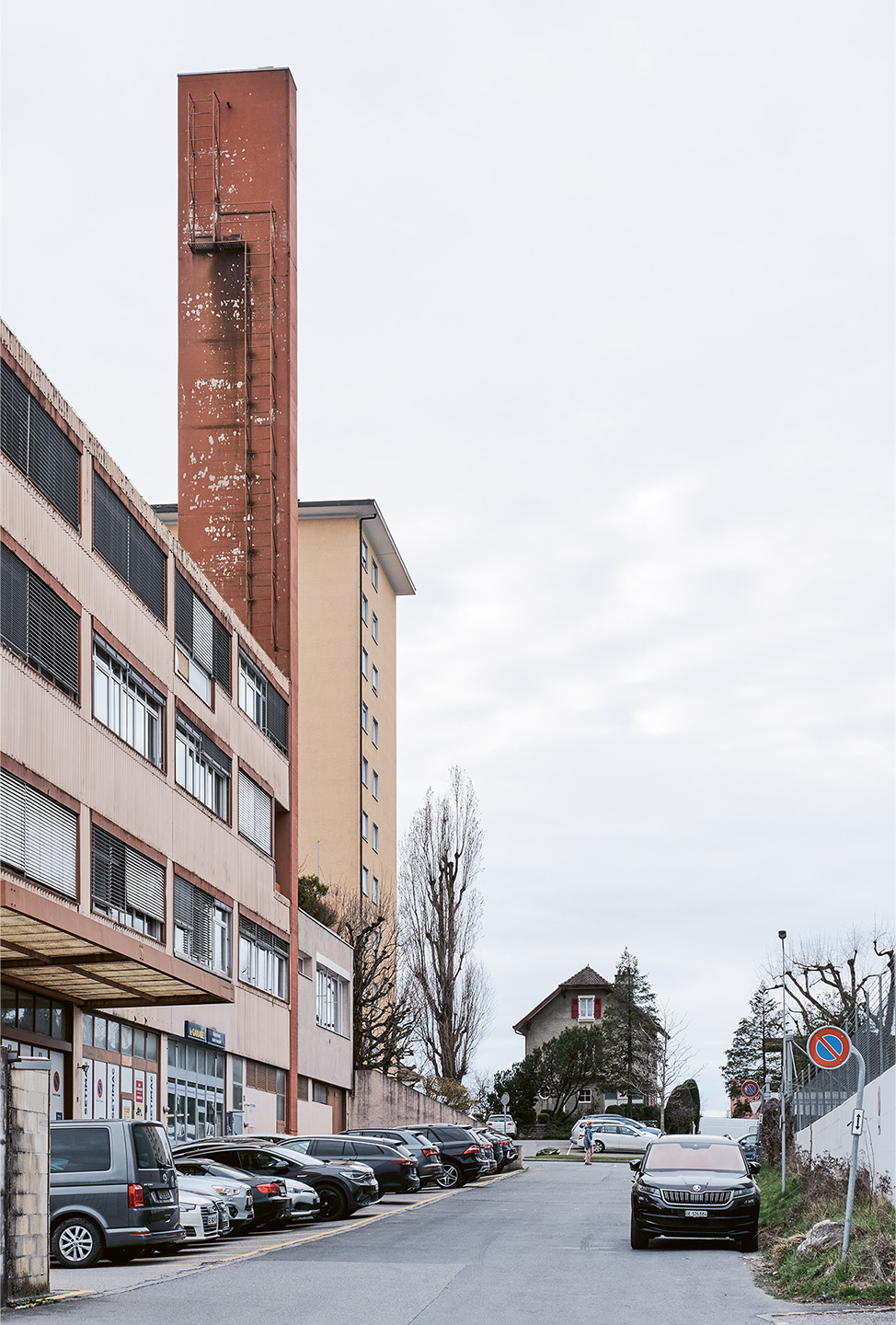 Avenue de Longemalle. Premier plan: bâtiment industriel (1955 puis 1970), zone d’activités économiques B (ZAE B): activités artisanales. Second plan: maison à deux logements (1931), zone d’habitation de moyenne densité B (ZHMD B): quartier d’immeubles.