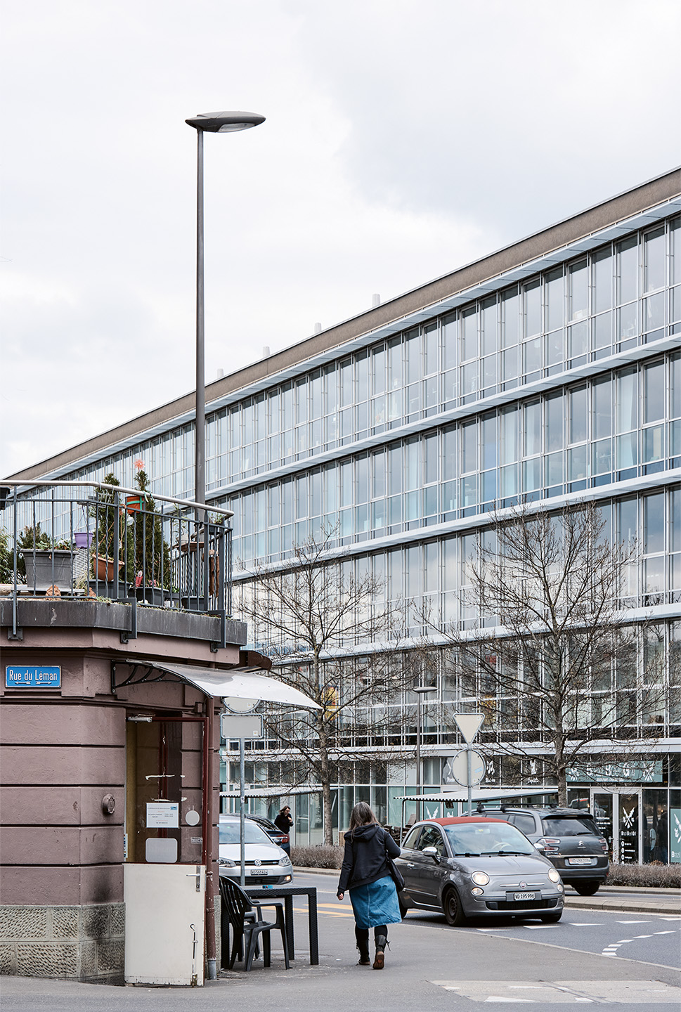 Rue du Caudray. Premier plan: café du Léman (1904), zone d’habitation de moyenne densité B (ZHMD B): quartier d’immeubles; secteur de protection de site bâti B ; recensement architectura : note 3. Second plan: bâtiment commercial (2009), plan de quartier Renens Entrepôts.