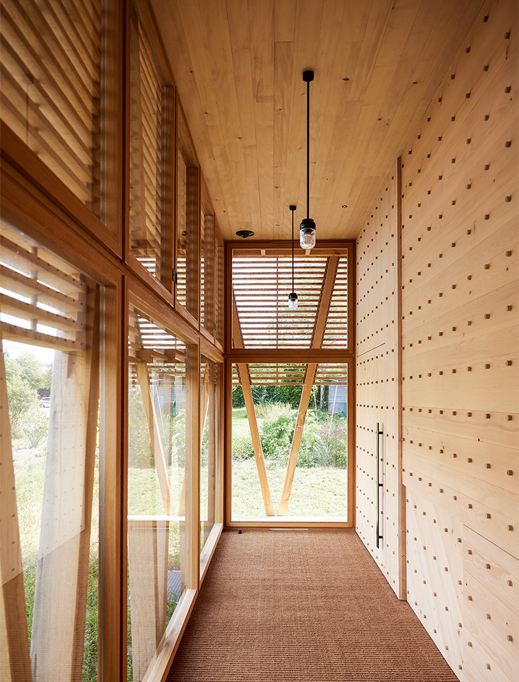 Von der in natürlichen Materialien gehaltenen Vorzone zum  Archiveingang öffnet sich der Blick nochmals auf den Garten. Der Raum übernimmt auch die Funktion eines Klimapuffers.