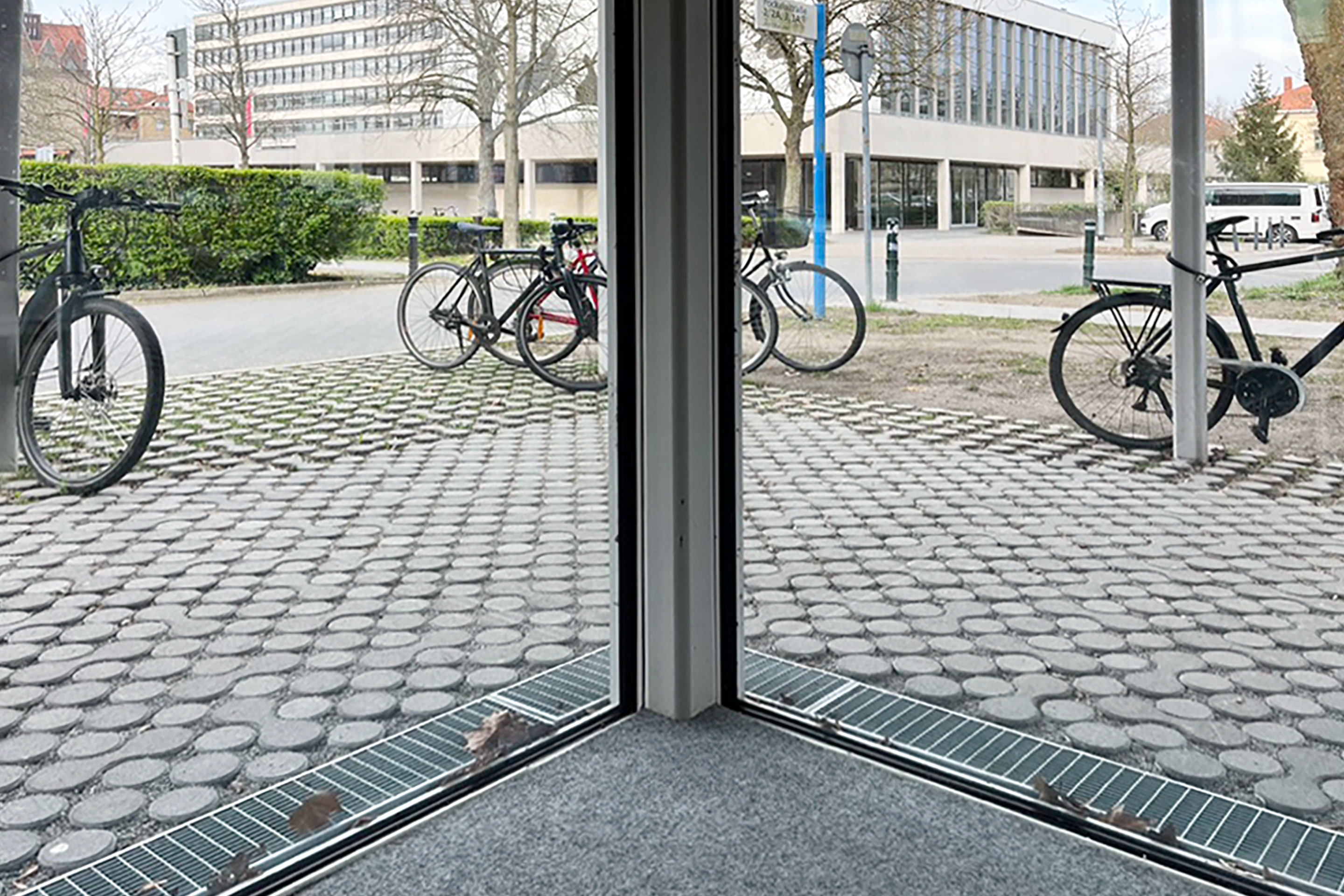 Noyée dans le sol, sans cadre apparent, la façade vitrée est dans le style Mies van der Rohe