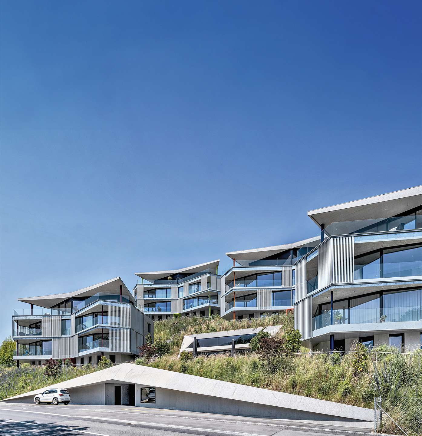 Das Ensemble «Residenz Rigiblick»: Oberirdisch sichtbar sind die vier schmetterlingsförmigen Punktbauten, der Einschnitt mit der vor der Lounge liegenden Terrasse sowie der Eingang zu den Verbindungstunneln.