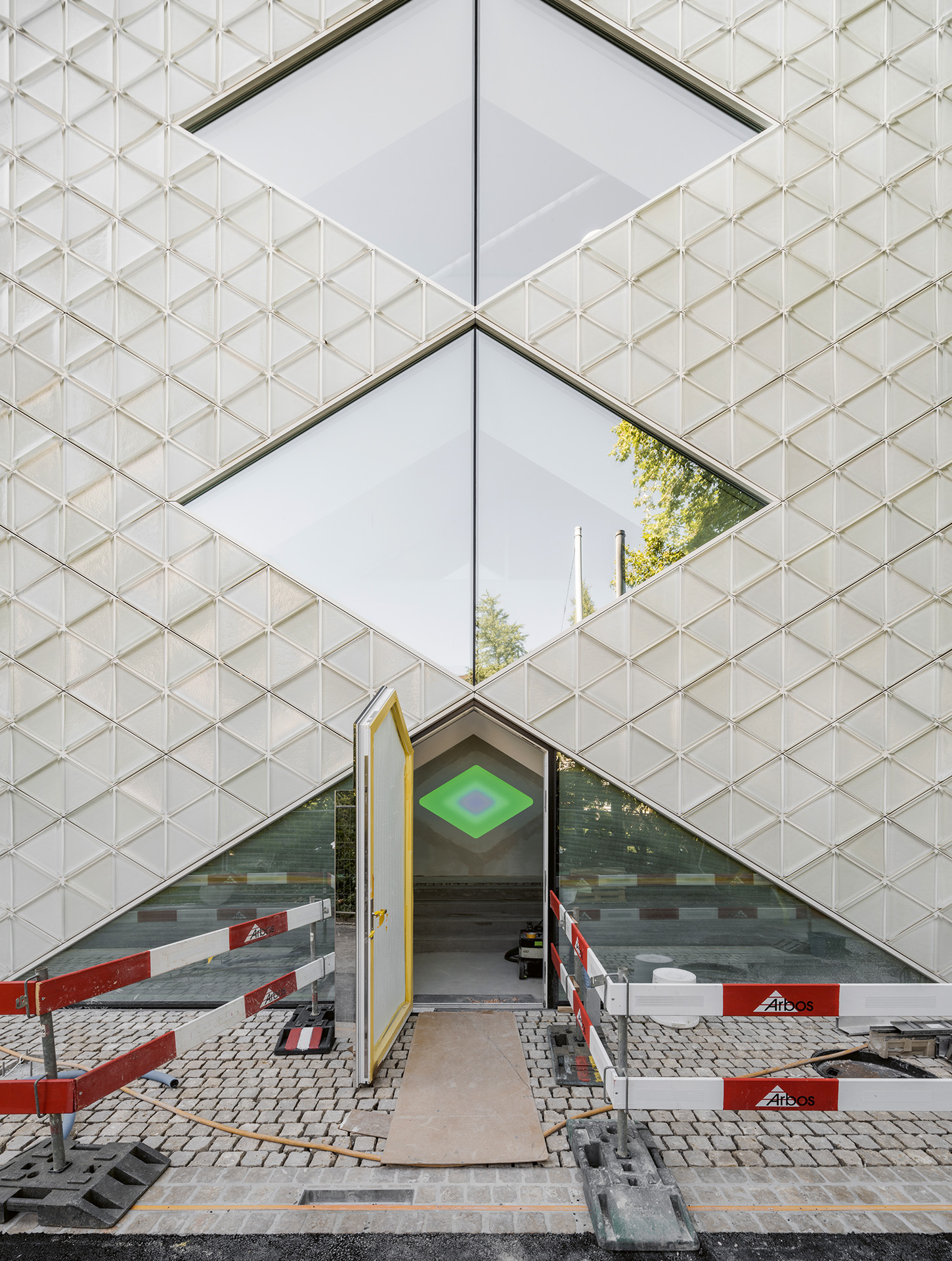 Die leuchtende Raute von James Turrell markiert den Eingang und weist den Weg zur Dachterrasse.