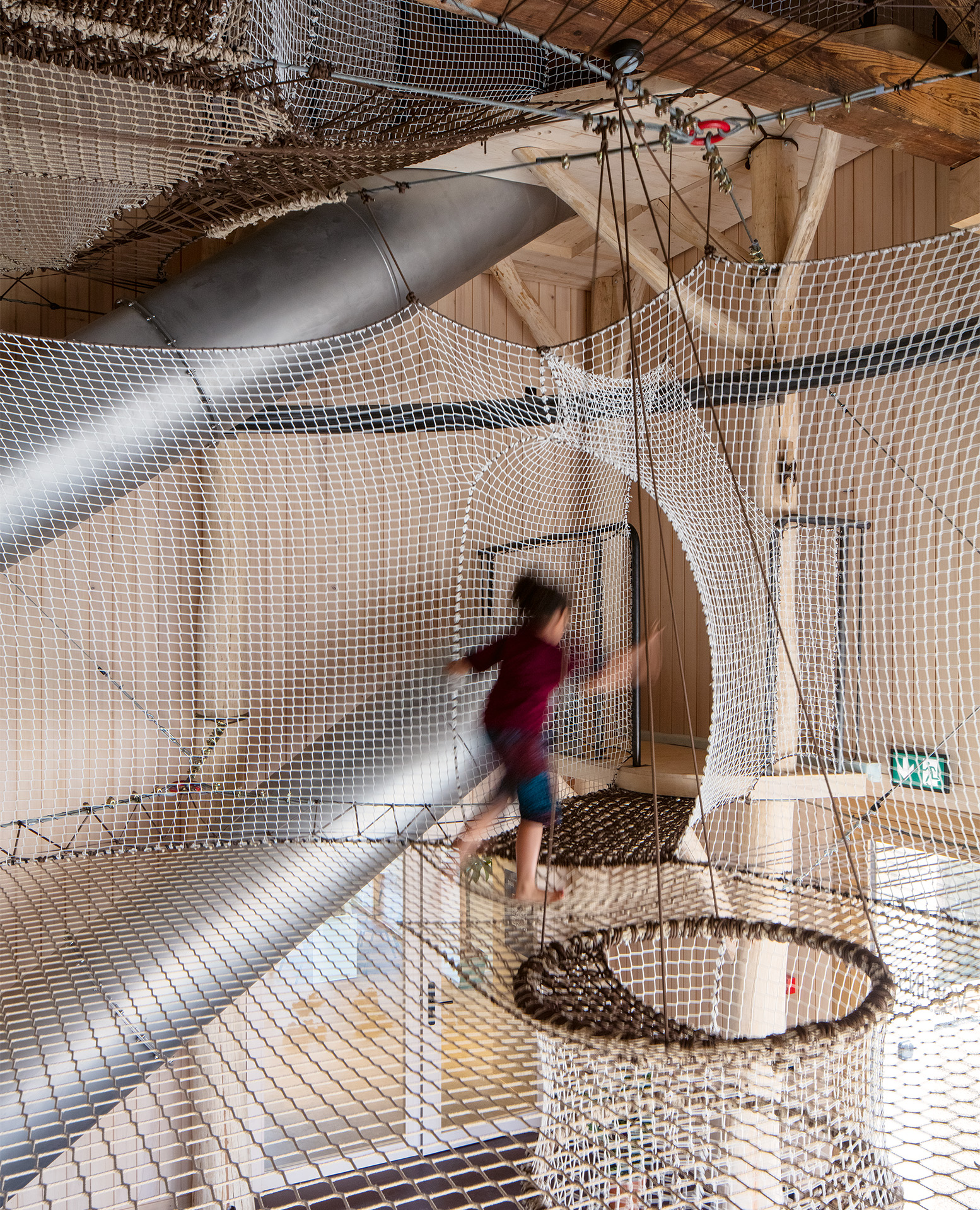 Pour investir la verticalité de la grange, FAZ architectes a imaginé un univers de filets dans lequel les utilisateur·trices créent leur propre parcours.