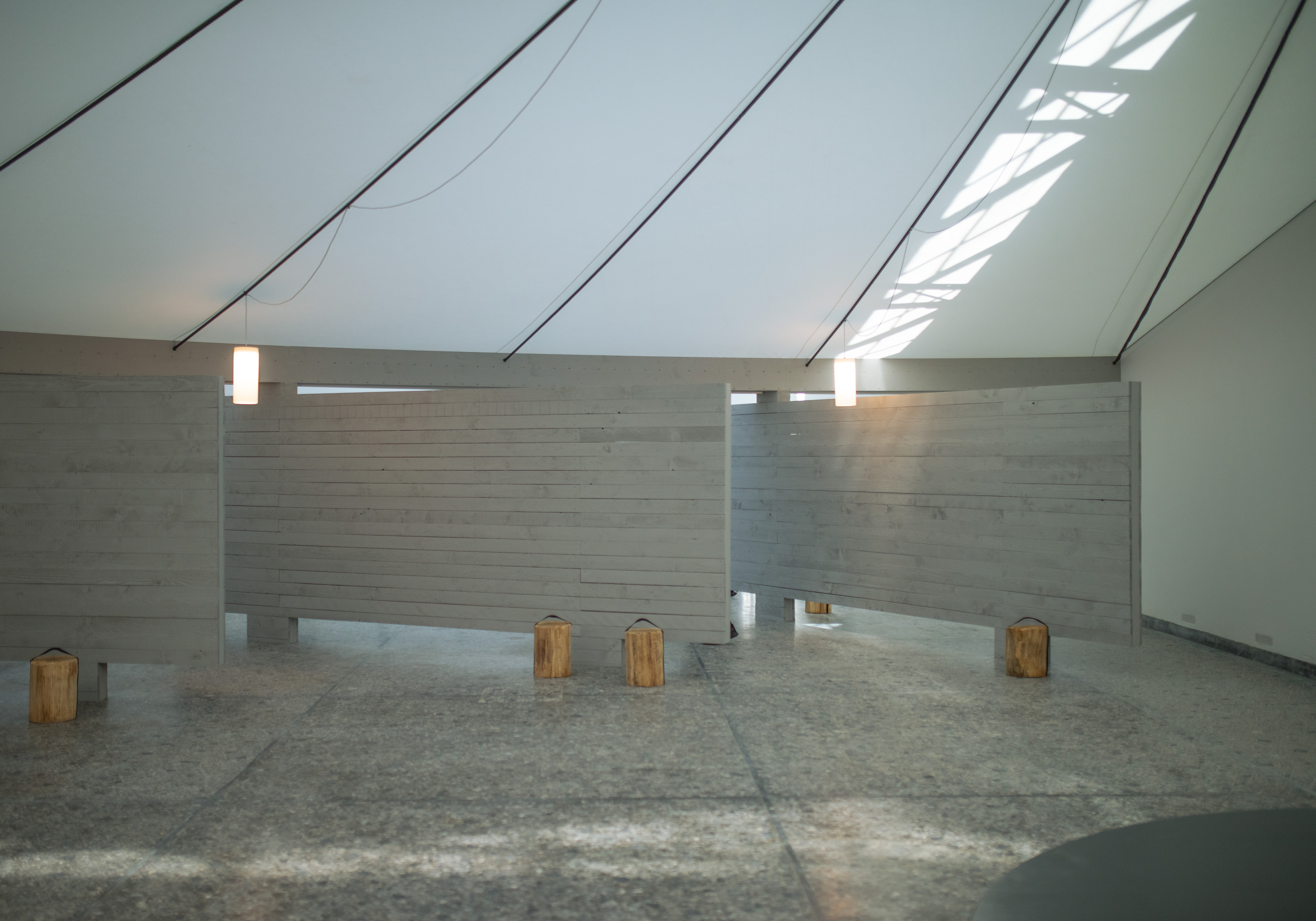 Die Holzwände - im Original mit Exponaten behangen - wirken wie Kulissengassen, durch die man eine Bühne betritt.