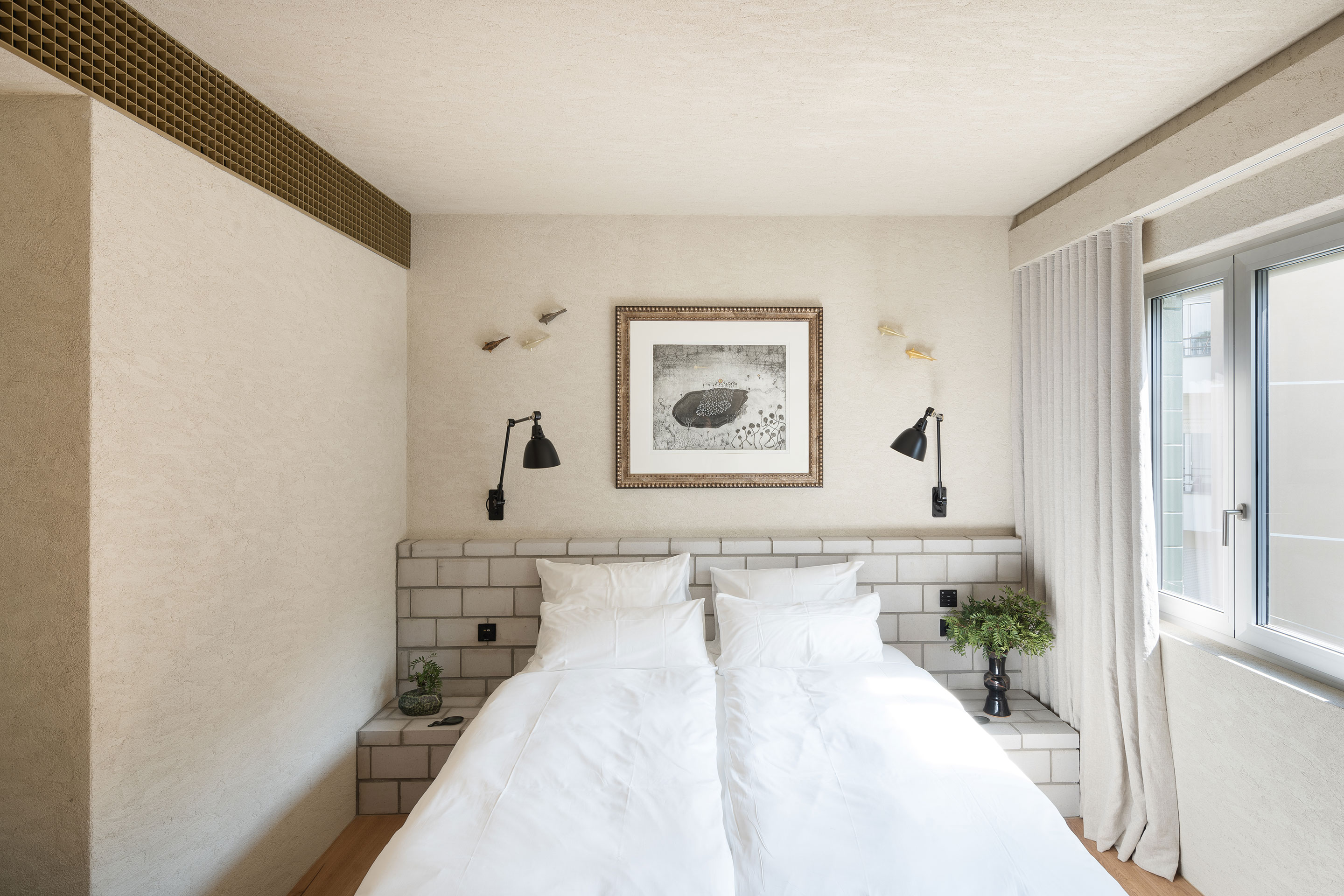 Afin que tous les éléments de construction soient visibles, la ventilation n'est pas dissimulée, mais mise en valeur par une grille murale qui reprend le motif en damier de la façade (en haut à gauche).