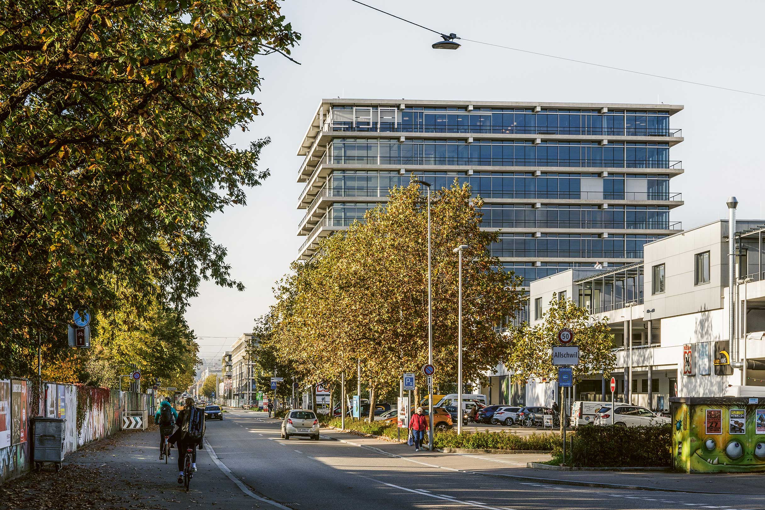 Dank eines Quartierplans überragt das 40 m hohe Alba Haus die anderen Bauten im Bachgraben; es bildet den Auftakt zum Areal. Geschossumlaufende Balkone zeichnen die Tragstruktur nach. Über dem öffentlich zugänglichen Erdgeschoss mit Dienstleistungen befinden sich flexible Arbeitsbereiche für Start-ups und etablierte Unternehmen. • Bauherrschaft: JP Bachgraben; Architektur: Herzog &amp; de Meuron; Fertigstellung: 2023