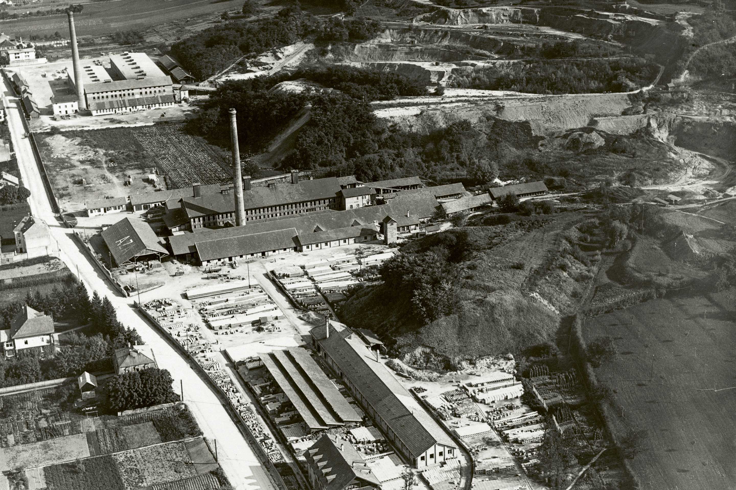 Bis heute stehen an der Binningerstrasse Bauten der ehemaligen Ziegeleibetriebe. Die Topografie ist durch den damit einhergehenden Lehmabbau überformt. Bilddatierung zwischen 1918 und 1937.